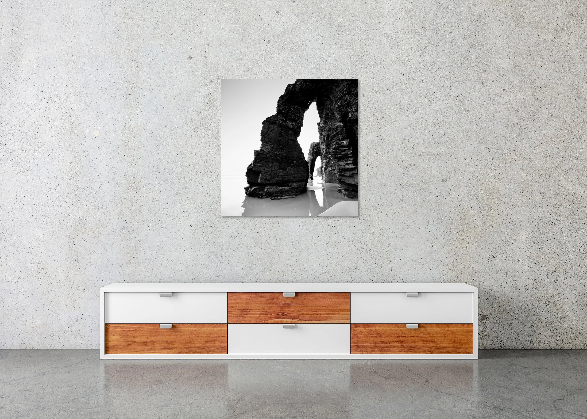 Black and white coastal photo of rugged cliffs and sea arches reflected in wet sand, photo print mounted to Dibond, frameless