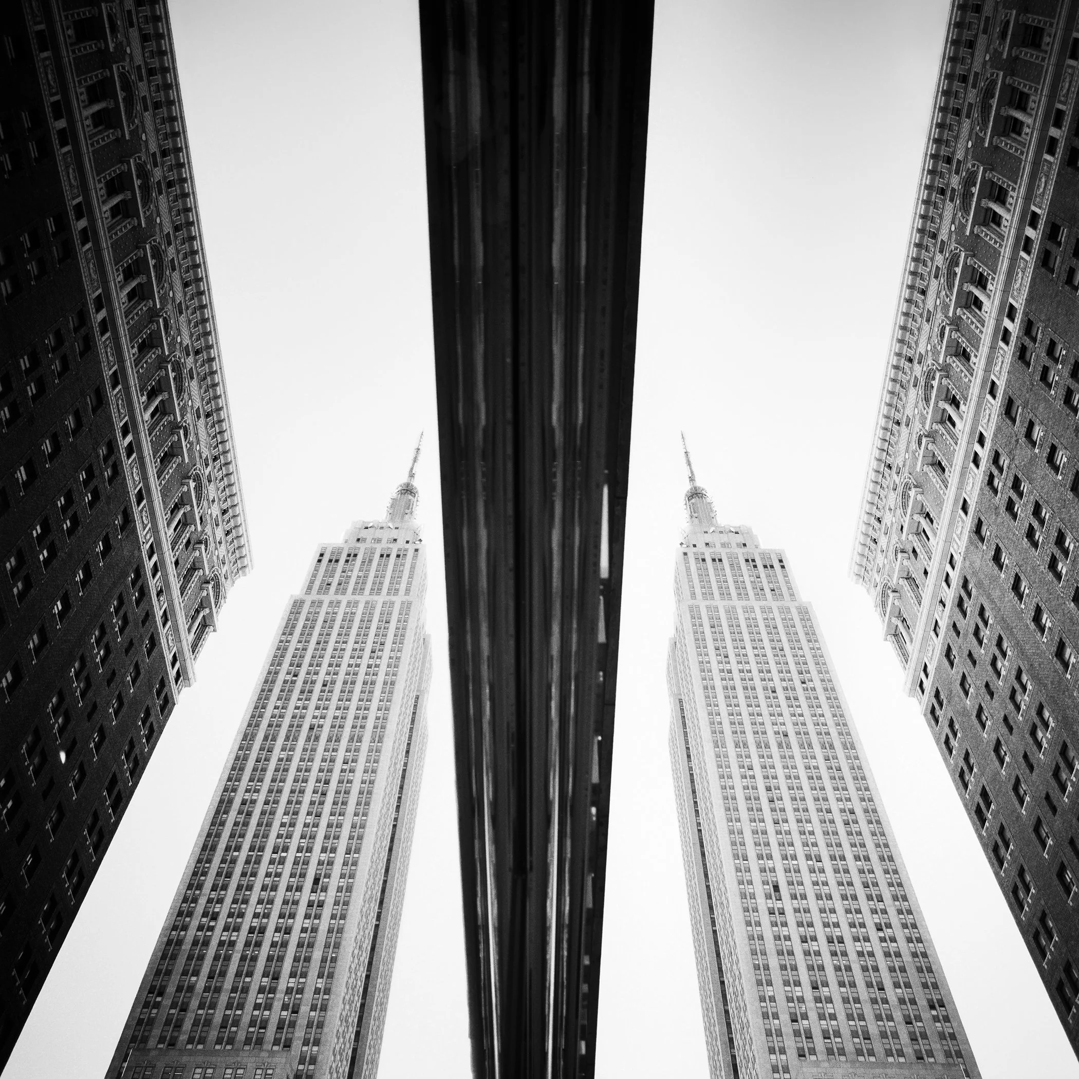 © 2016 Gerald Berghammer - Black-and-white architectural photograph showing symmetrical skyscrapers from a low-angle perspective with strong linear focus.