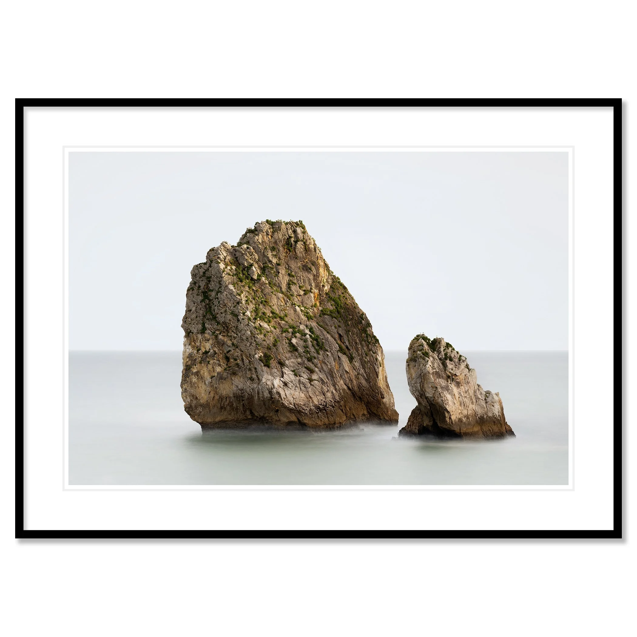Gerald Berghammer - Color long exposure seascape Photography. Two large rocks protruding from the calm Atlantic Ocean, with a plain, hazy sky. Classic framed black