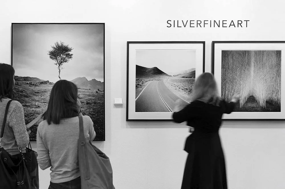 Visitors viewing black-and-white fine art photography at SILVERFINEART Gallery in Vienna, featuring works by Gerald Berghammer.