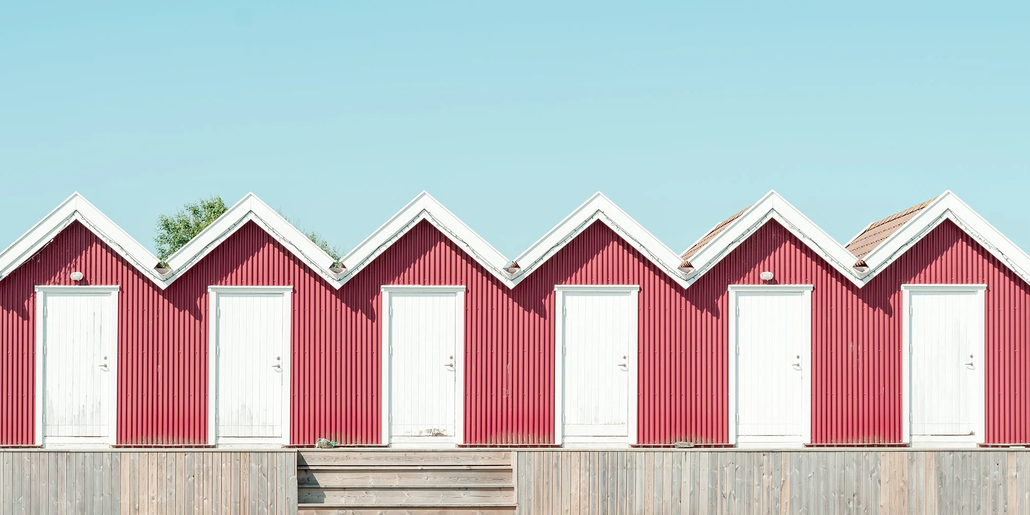 Red Beach Huts Study 1, minimalist colour fine art photograph of red wooden beach huts in Sweden by Gerald Berghammer.