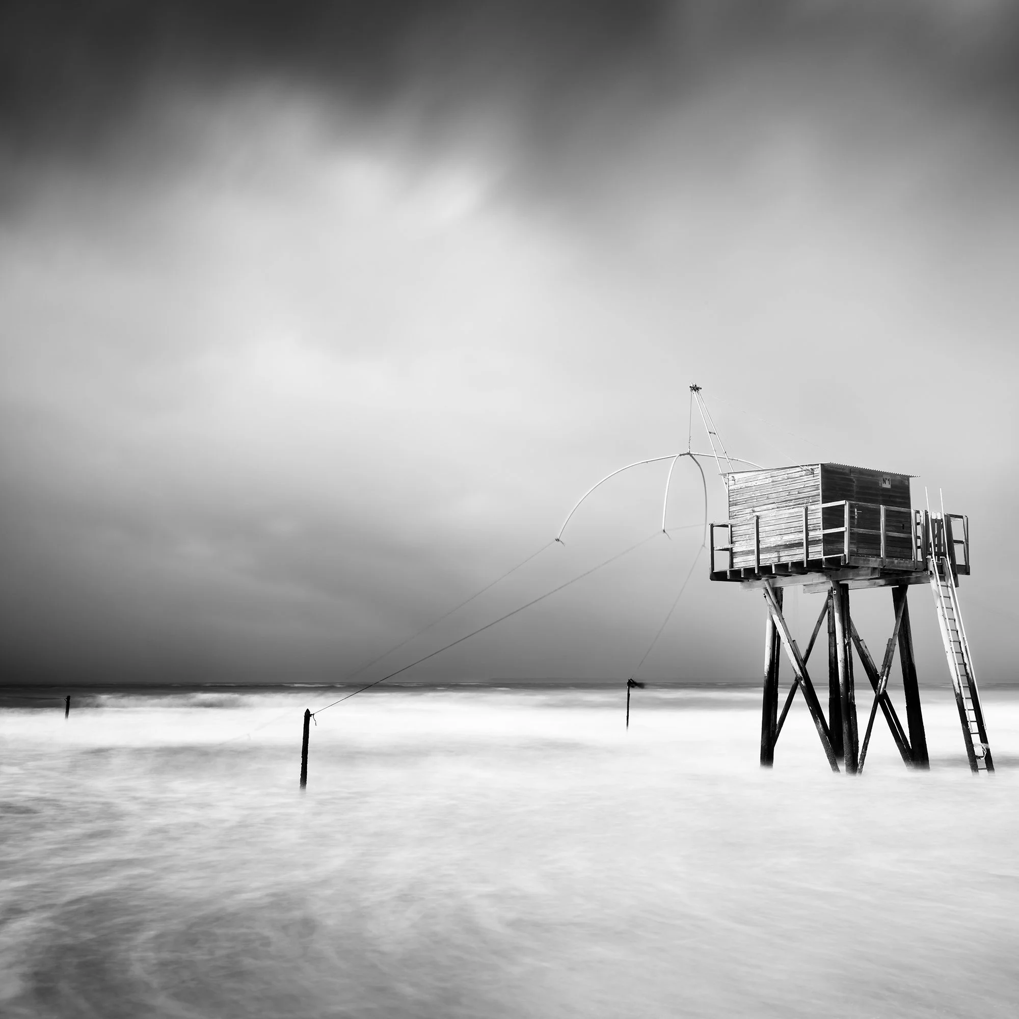 Detail view of Fishing Hut on Stilts Study 4 showing the main fishing hut against a dramatic sky and long-exposure sea by Gerald Berghammer.