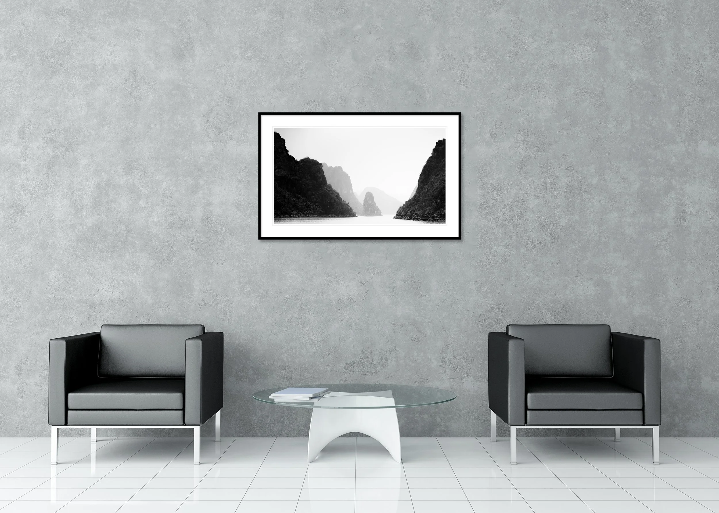 Black-and-white minimalist photograph of misty limestone karsts rising from calm water in Ha Long Bay, Vietnam. Archival Pigment Print – Classic Frame with Passe-Partout