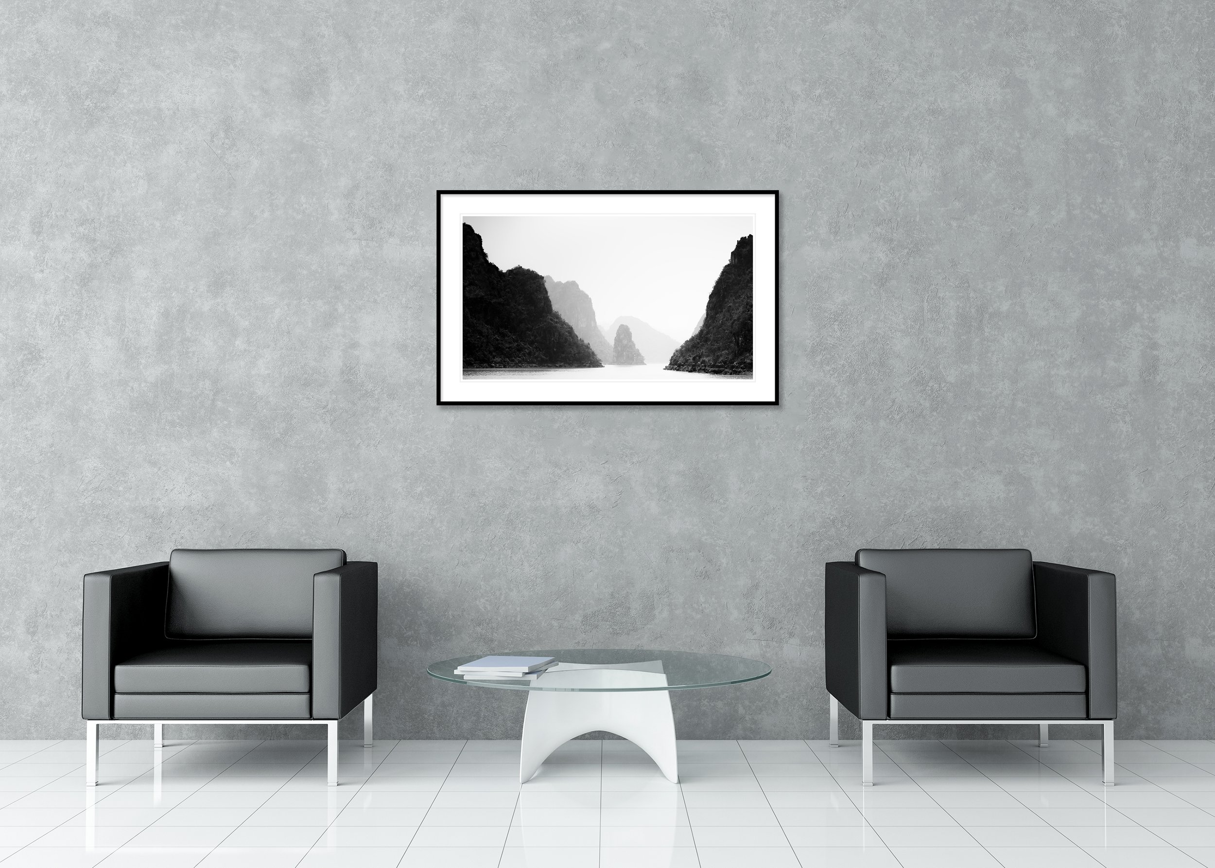 Black-and-white minimalist photograph of misty limestone karsts rising from calm water in Ha Long Bay, Vietnam. Archival Pigment Print – Classic Frame with Passe-Partout