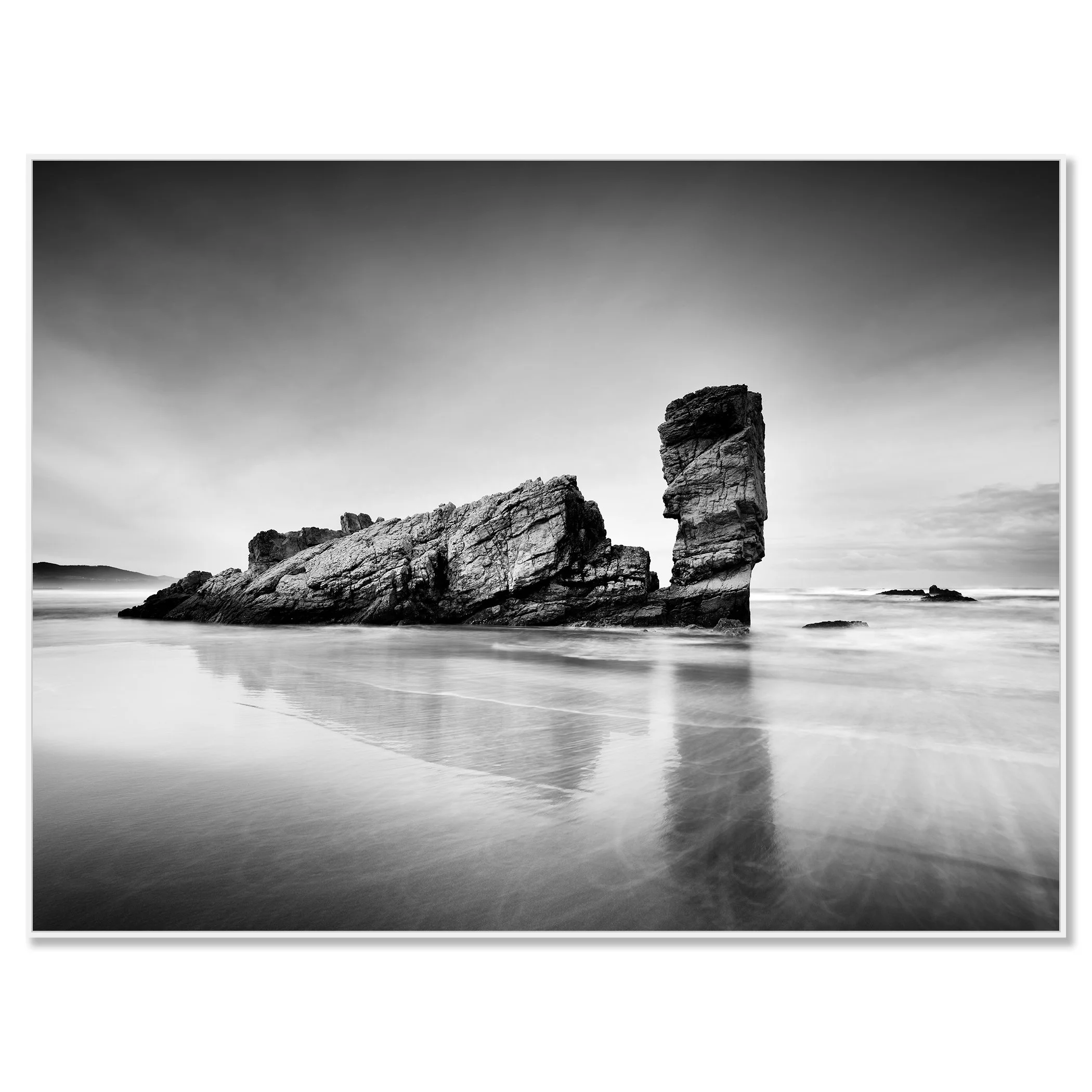 Black-and-white coastal rock formation reflected on wet sand at low tide – framed ArtBox white