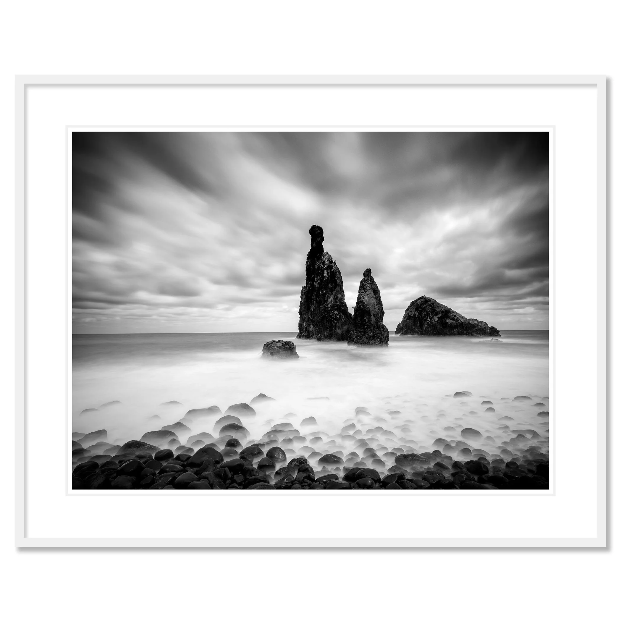 © 2021 Gerald Berghammer - Black and white seascape photography. Rocky seashore with three prominent sea stacks rising from the water, cloudy sky overhead. Classic framed white