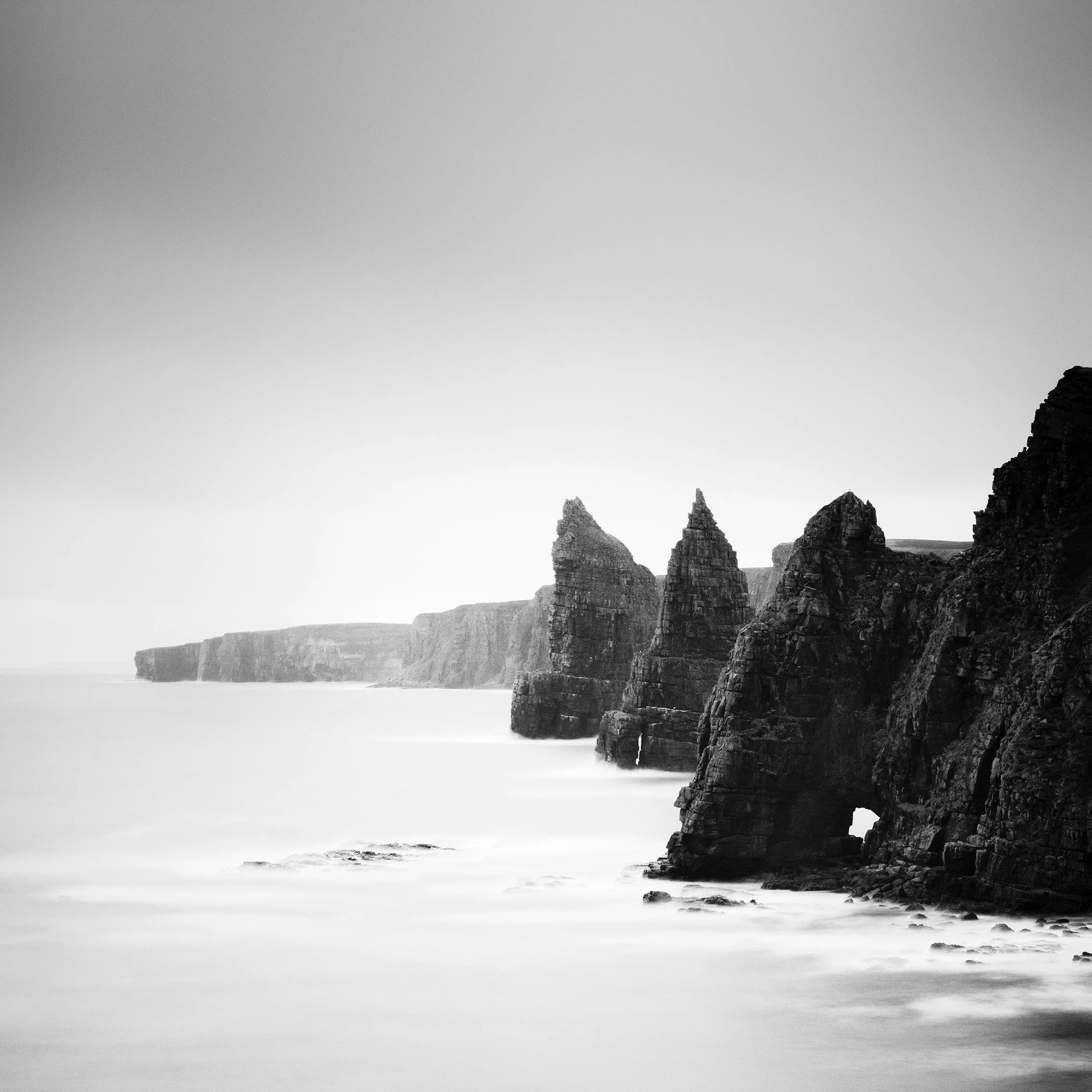 Duncansby Stacks Study 2, an analogue monochrome coastal landscape with dramatic sea stacks and smooth long-exposure water.