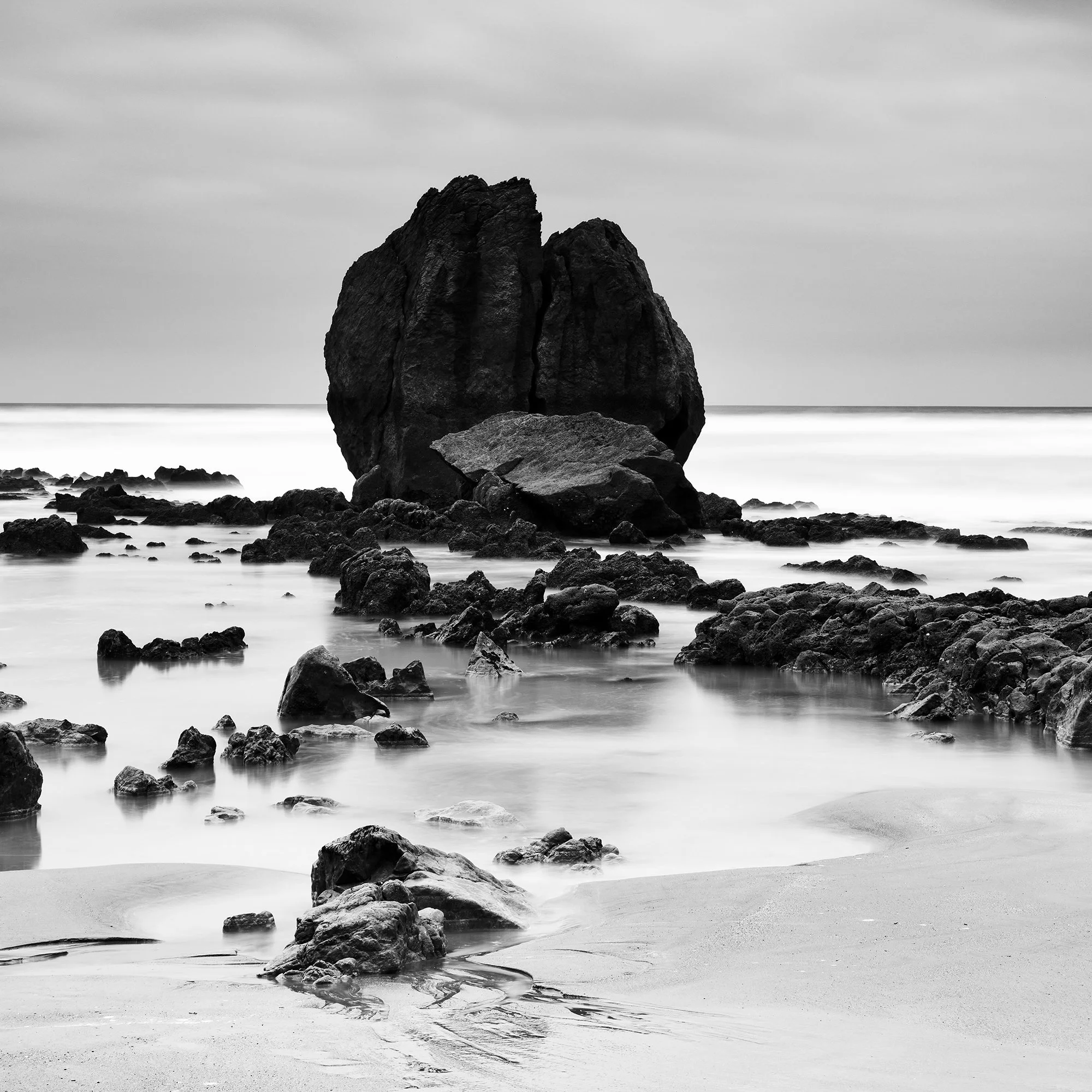 Rocks on the Shore Study 1 by Gerald Berghammer, close-up of a sculptural coastal rock formation surrounded by smooth seawater in France.