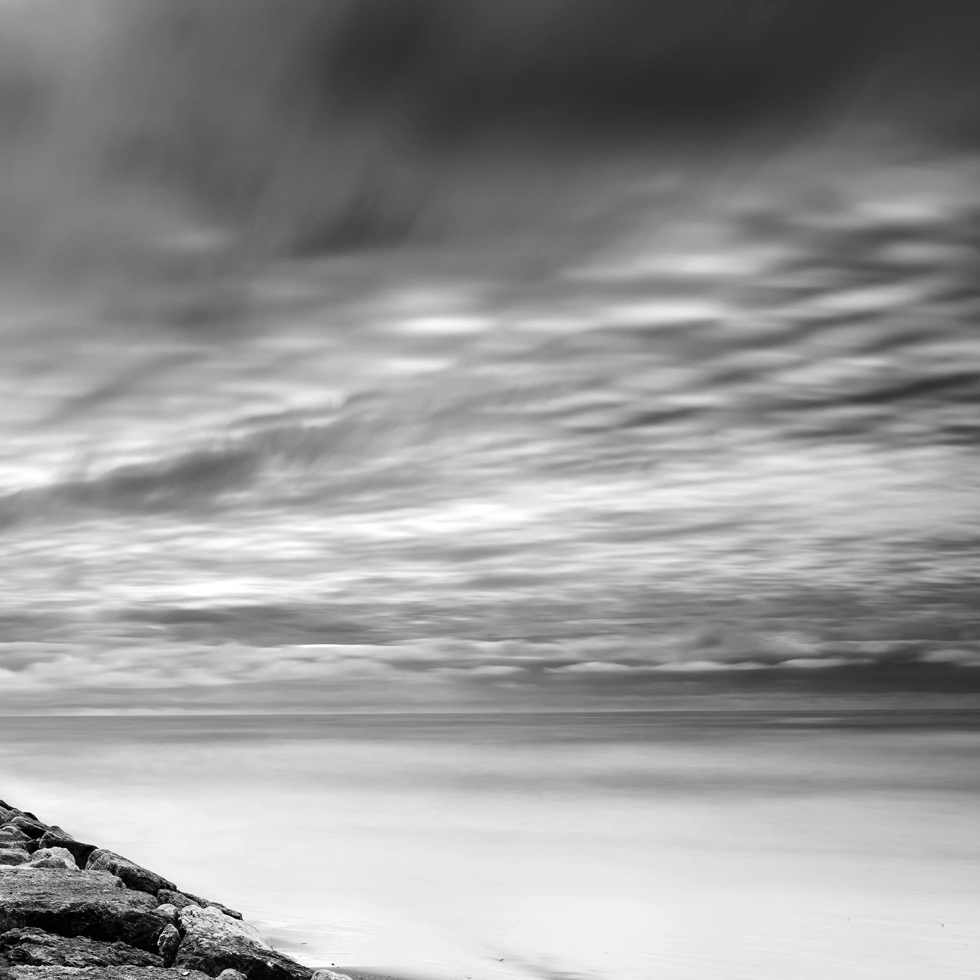 Rock Pier, Panorama Study 1 by Gerald Berghammer, detail of sweeping clouds above the smooth sea and stone breakwater.