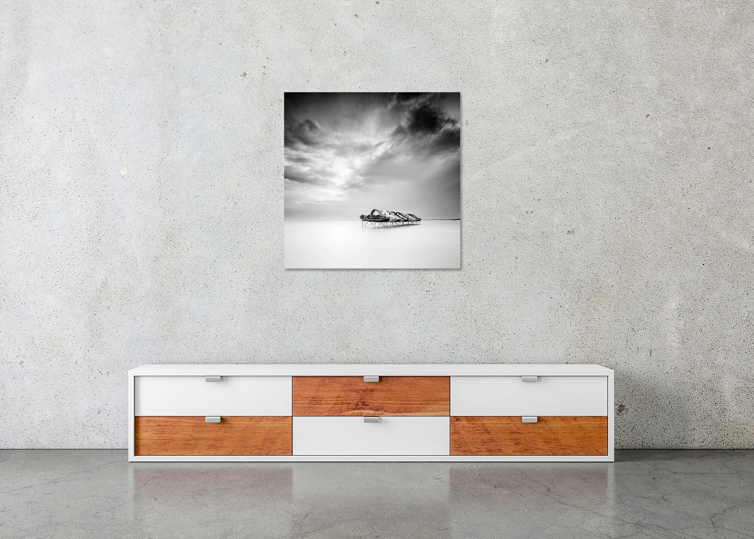 Black and white long-exposure photo of pedal boats on stilts in calm water beneath a cloudy sky, mounted to Dibond, frameless.