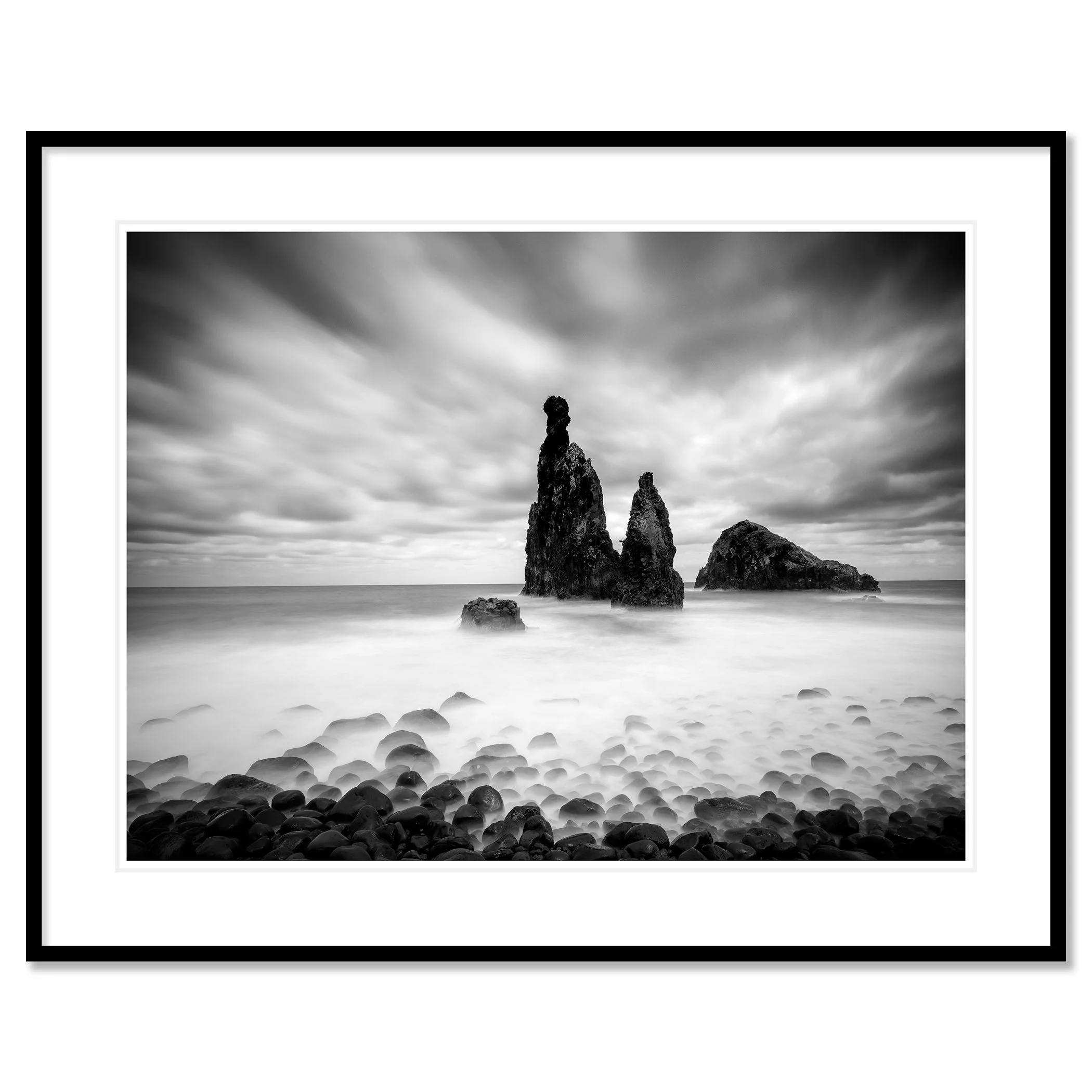 © 2021 Gerald Berghammer - Black and white seascape photography. Rocky seashore with three prominent sea stacks rising from the water, cloudy sky overhead. Classic framed black