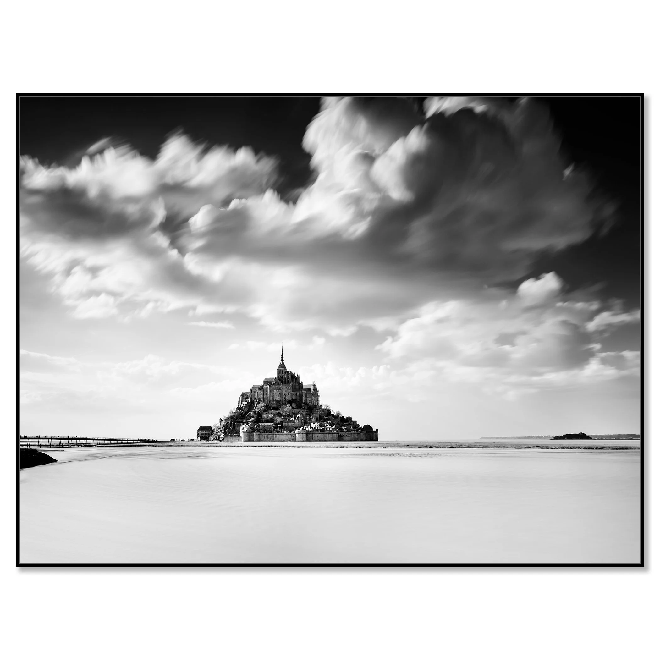© 2023 Gerald Berghammer - B&W photography. Mont Saint-Michel, a historic island with a tall spire and medieval architecture, surrounded by water and clouds. Chromaluxe framed black