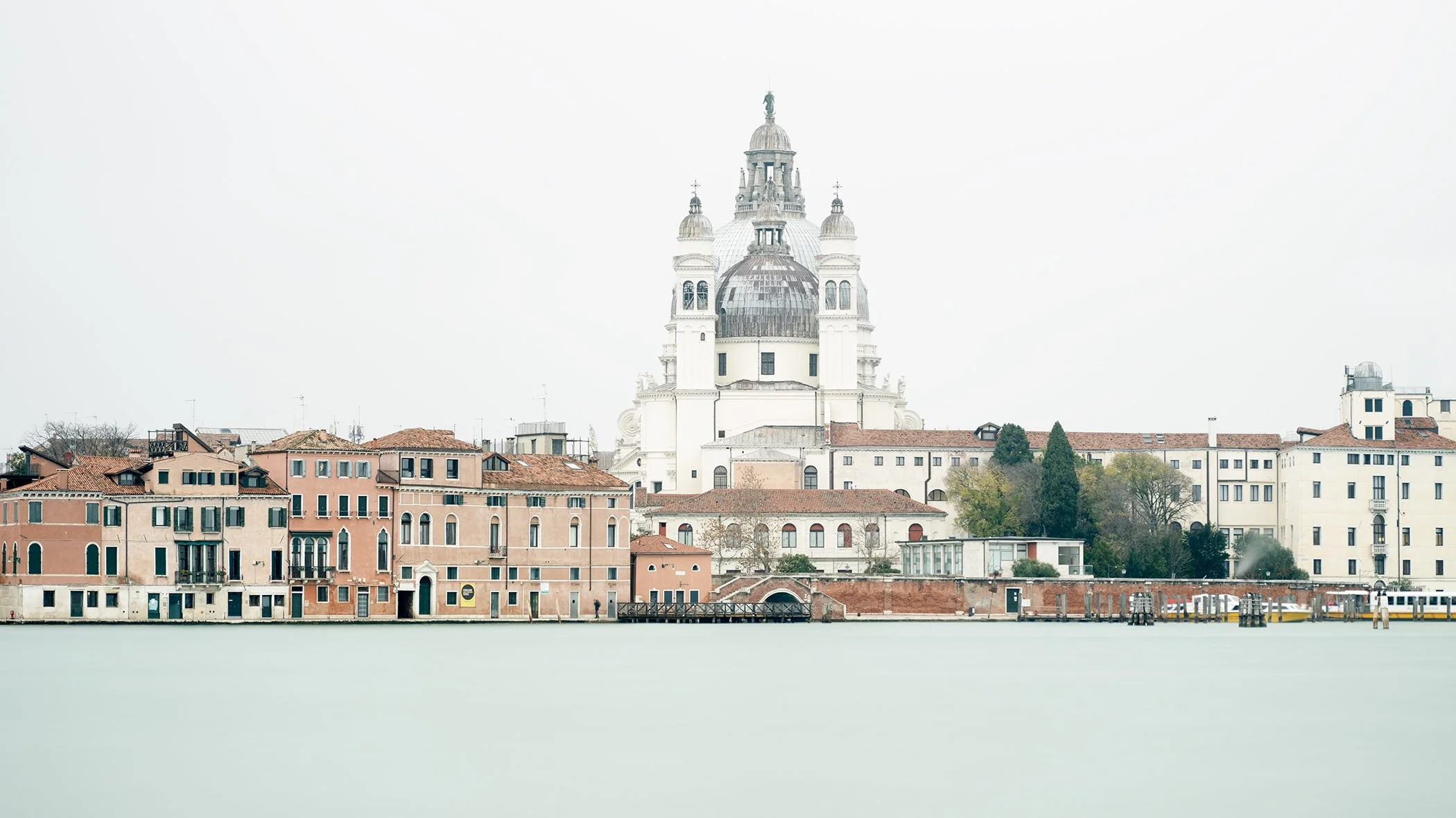 Church of the Santissimo Redentore rising above the Giudecca waterfront and calm Venetian Lagoon in Venice, Italy. Photo by Gerald Berghammer.