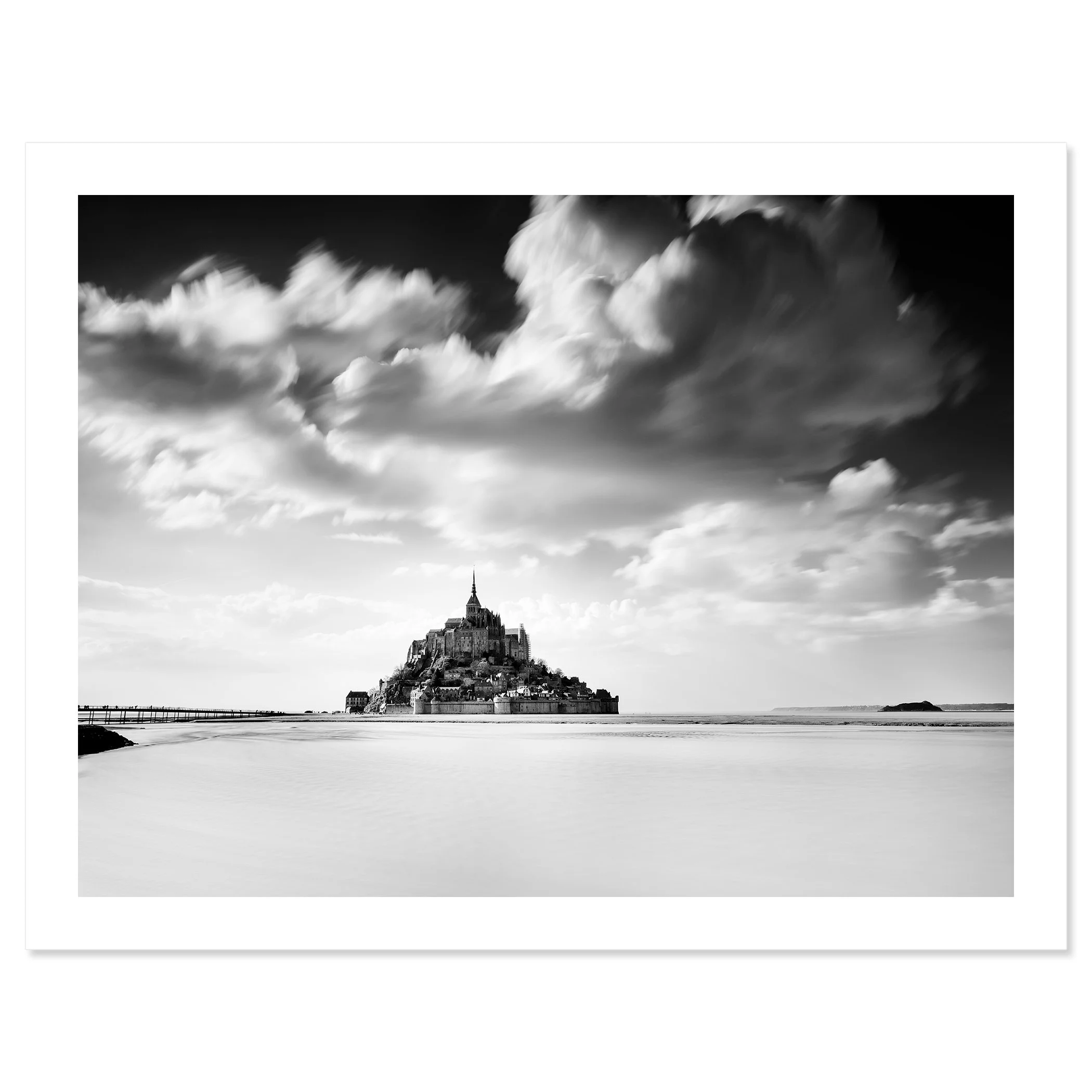 © 2023 Gerald Berghammer - B&W photography. Mont Saint-Michel, a historic island with a tall spire and medieval architecture, surrounded by water and clouds. Fine art print only
