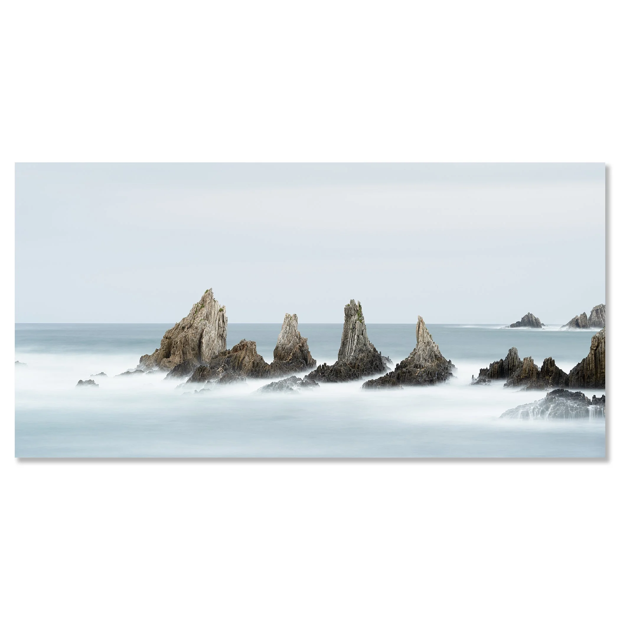 Long exposure minimalist seascape photo of jagged ocean rocks with misty water and cloudy sky – dibond frameless