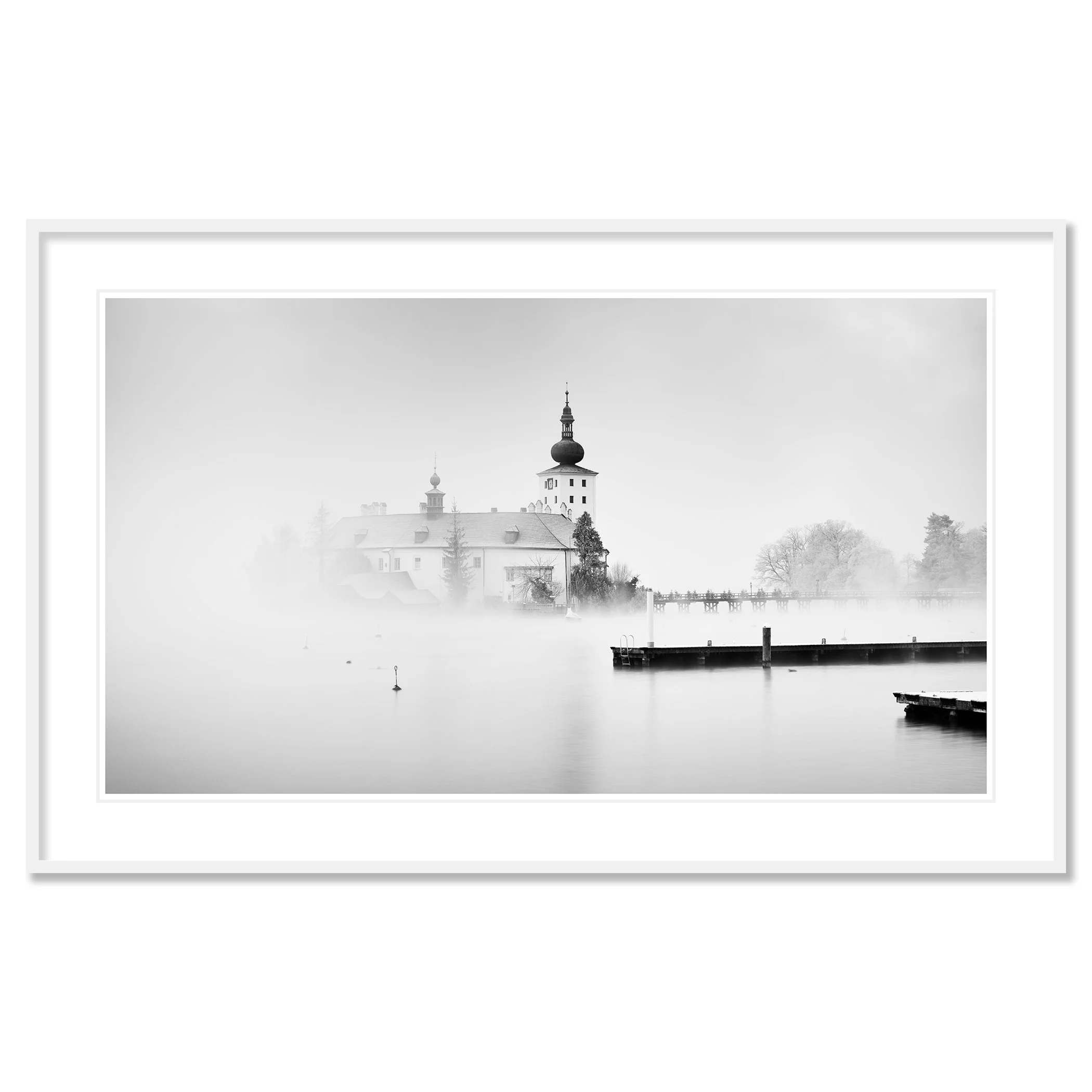 © 2022 Gerald Berghammer - Black and white cityscape photography. Schloss Ort - The historic church surrounded by mist over a lake with docks in the foreground. Classic framed white