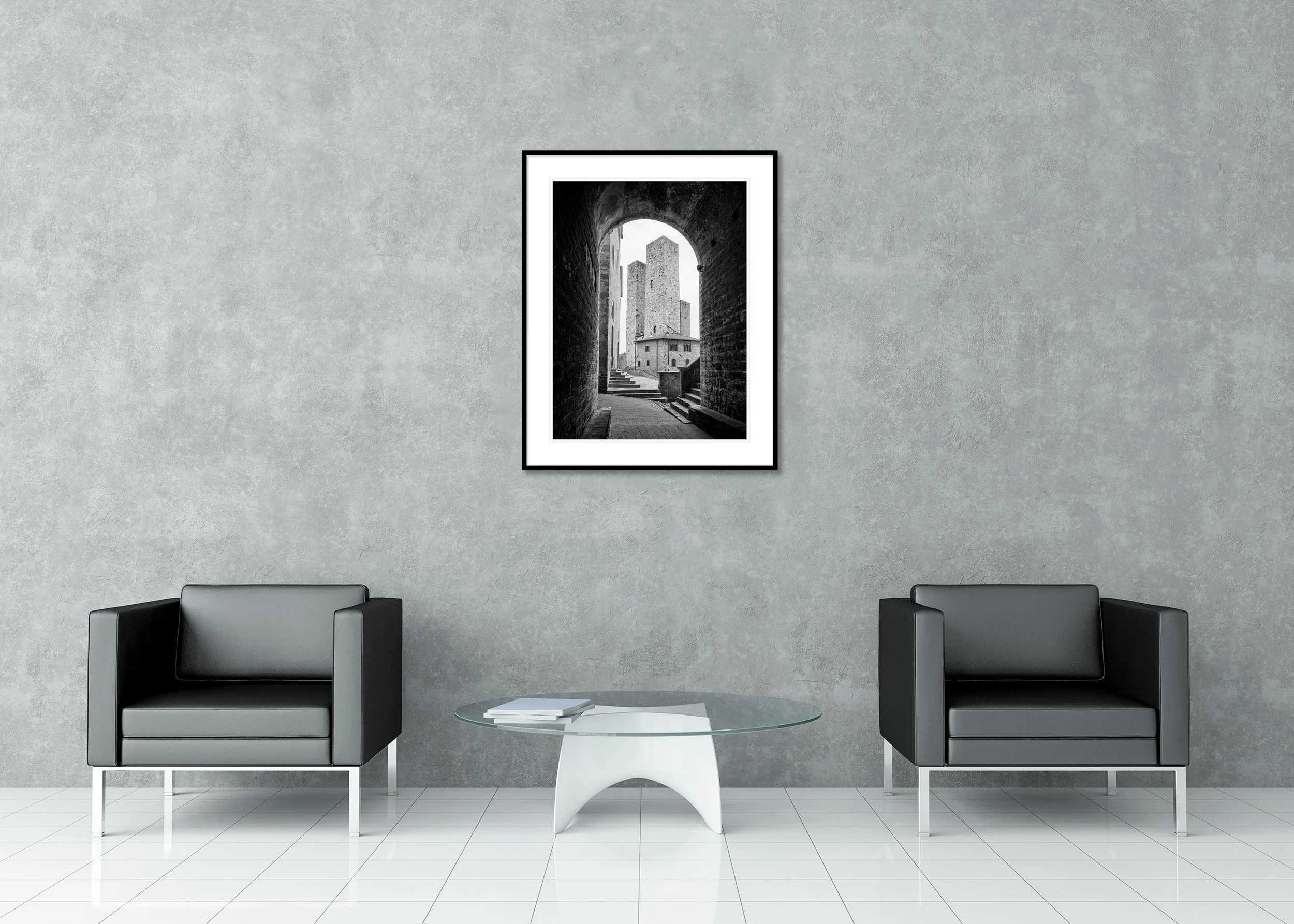 Black-and-white image of medieval stone towers in San Gimignano seen through a historic archway in Tuscany, Italy. Archival pigment print in a classic frame with passe-partout.