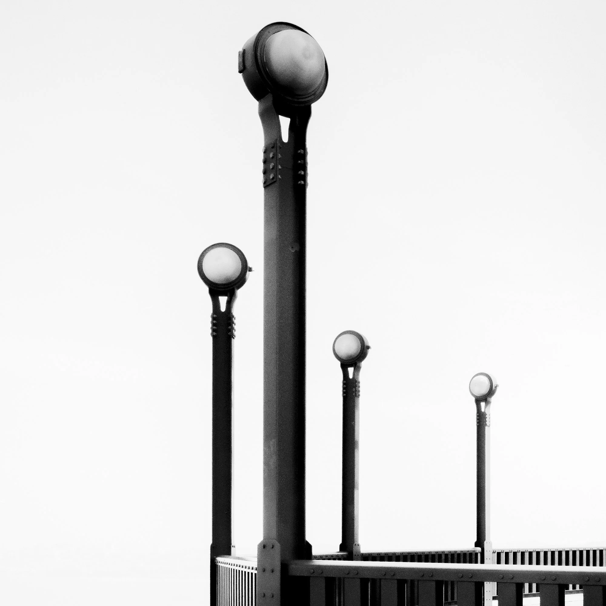 Close-up of the sculptural lamps and steel railing in Golden Gate Study 9, a black-and-white photograph by Gerald Berghammer.