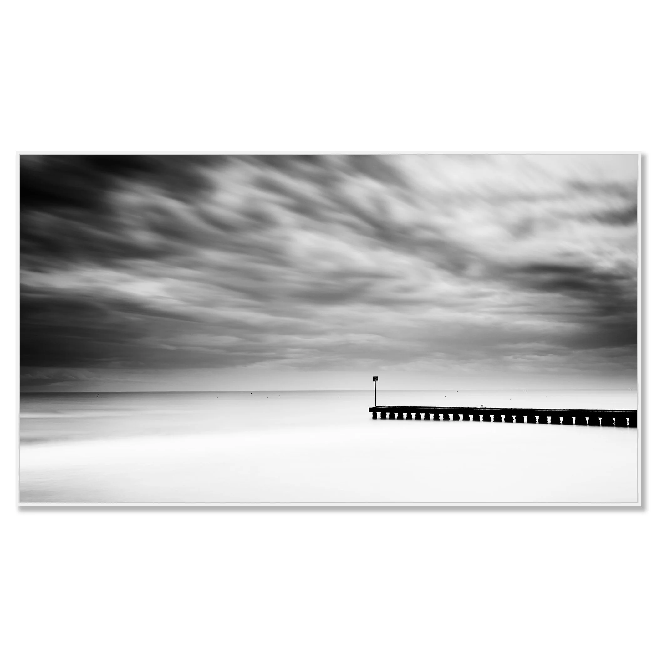 A wooden pier extending into a calm body of water with a cloudy sky and stormy weather – framed ArtBox white