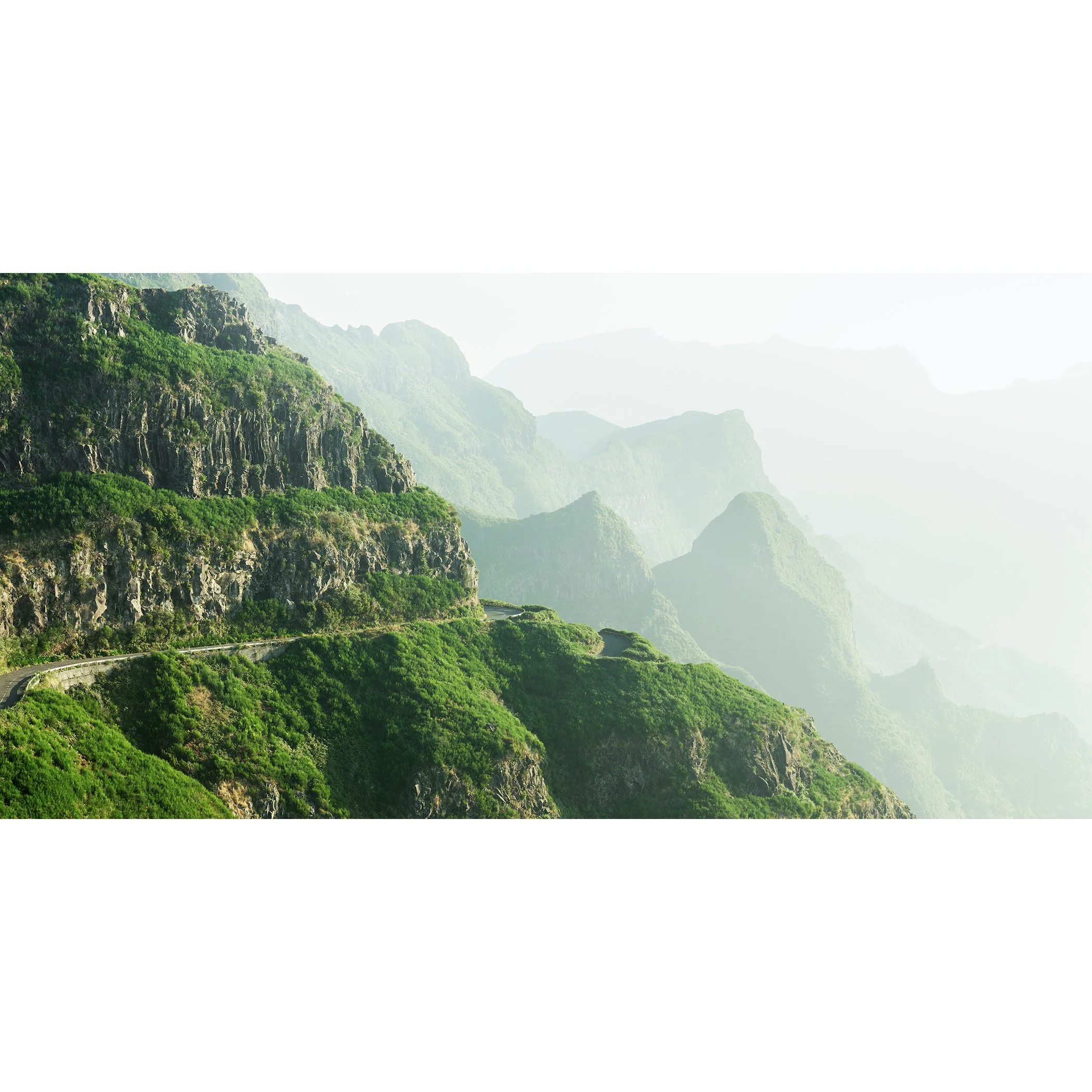 © 2021 Gerald Berghammer - Color Fine Art Landscape Photography. A winding mountain road through lush green cliffs and misty mountains in the background.