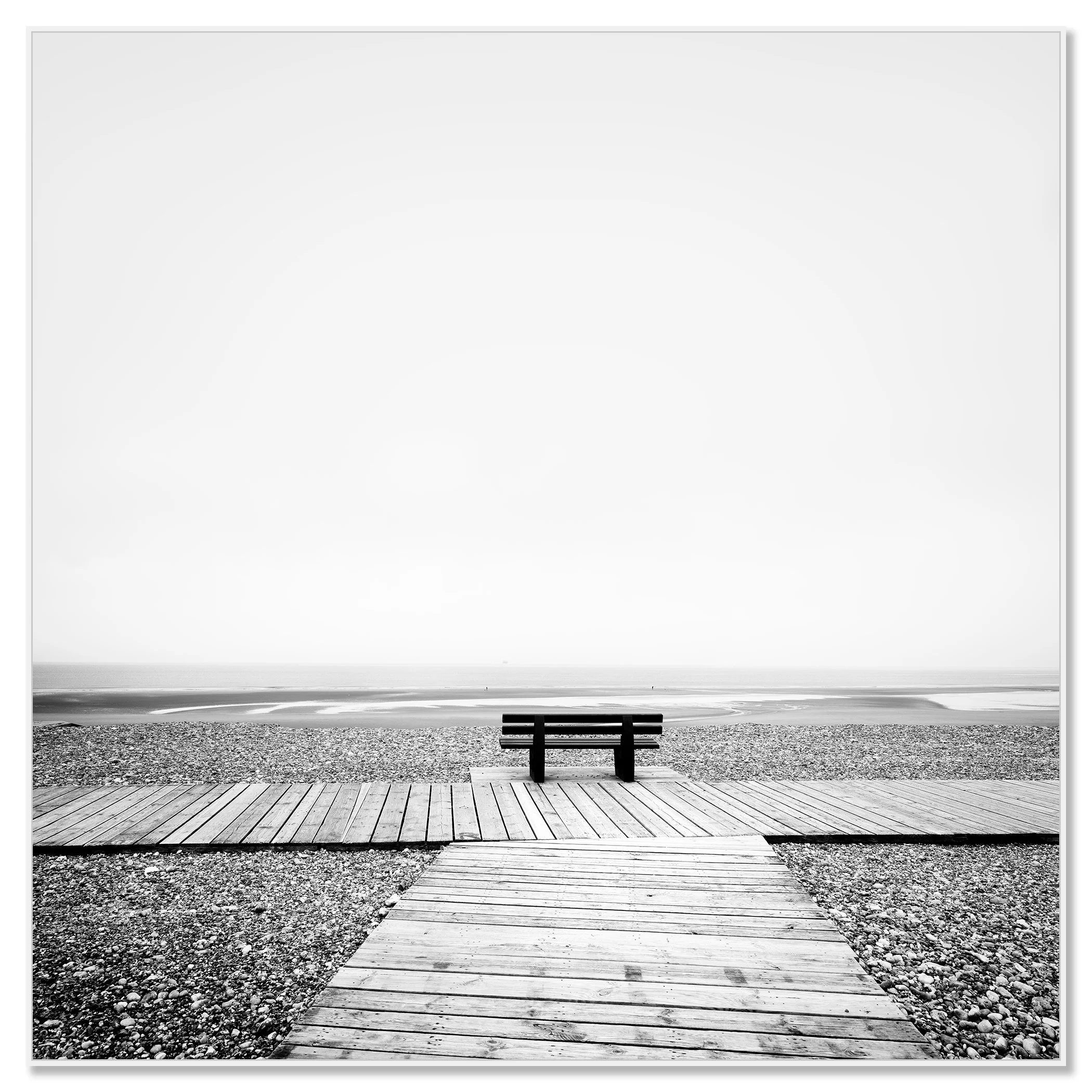 Wooden boardwalk and bench overlooking the Atlantic Ocean in black and white, with calm water and rocky shore – framed ArtBox white