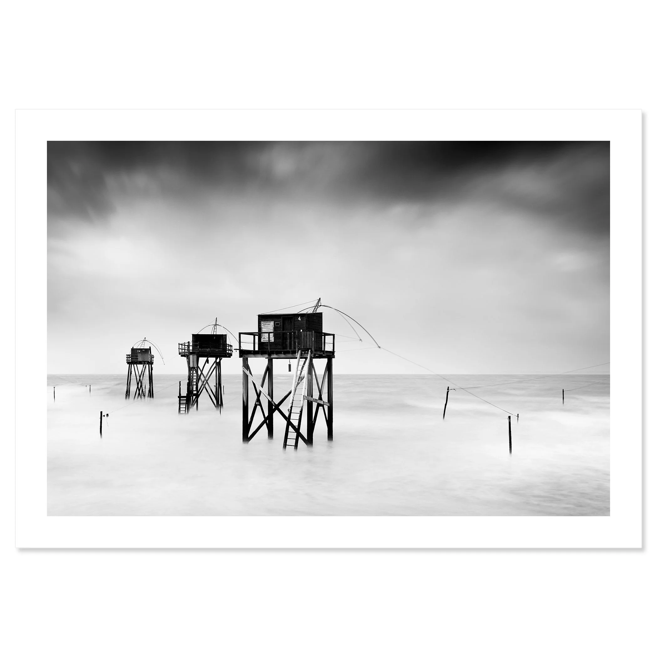 Monochrome long-exposure seascape with wooden fishing huts on stilts and misty water, Print only