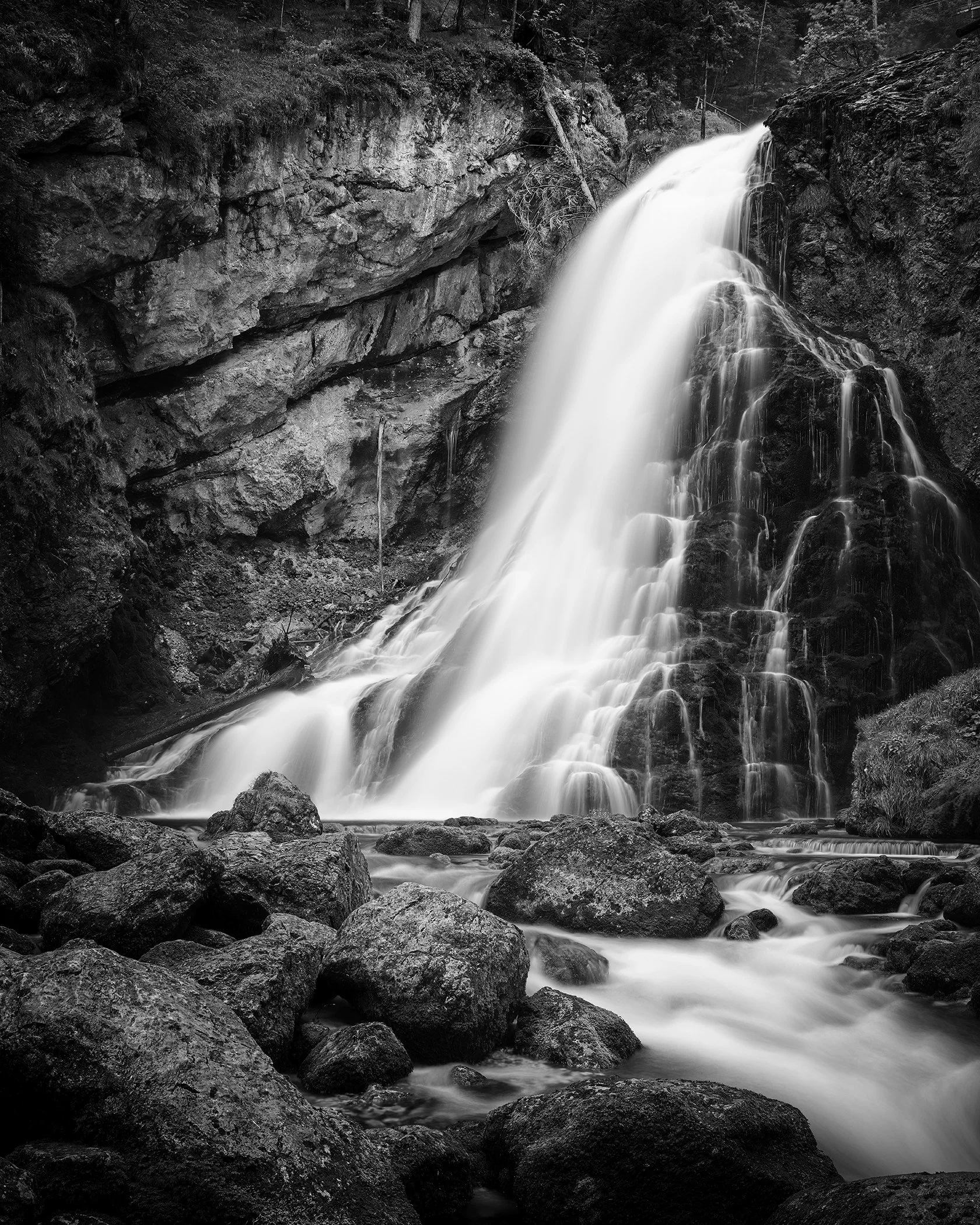 Golling Waterfall cascading through a rocky gorge in Austria, photographed in black and white by Gerald Berghammer.