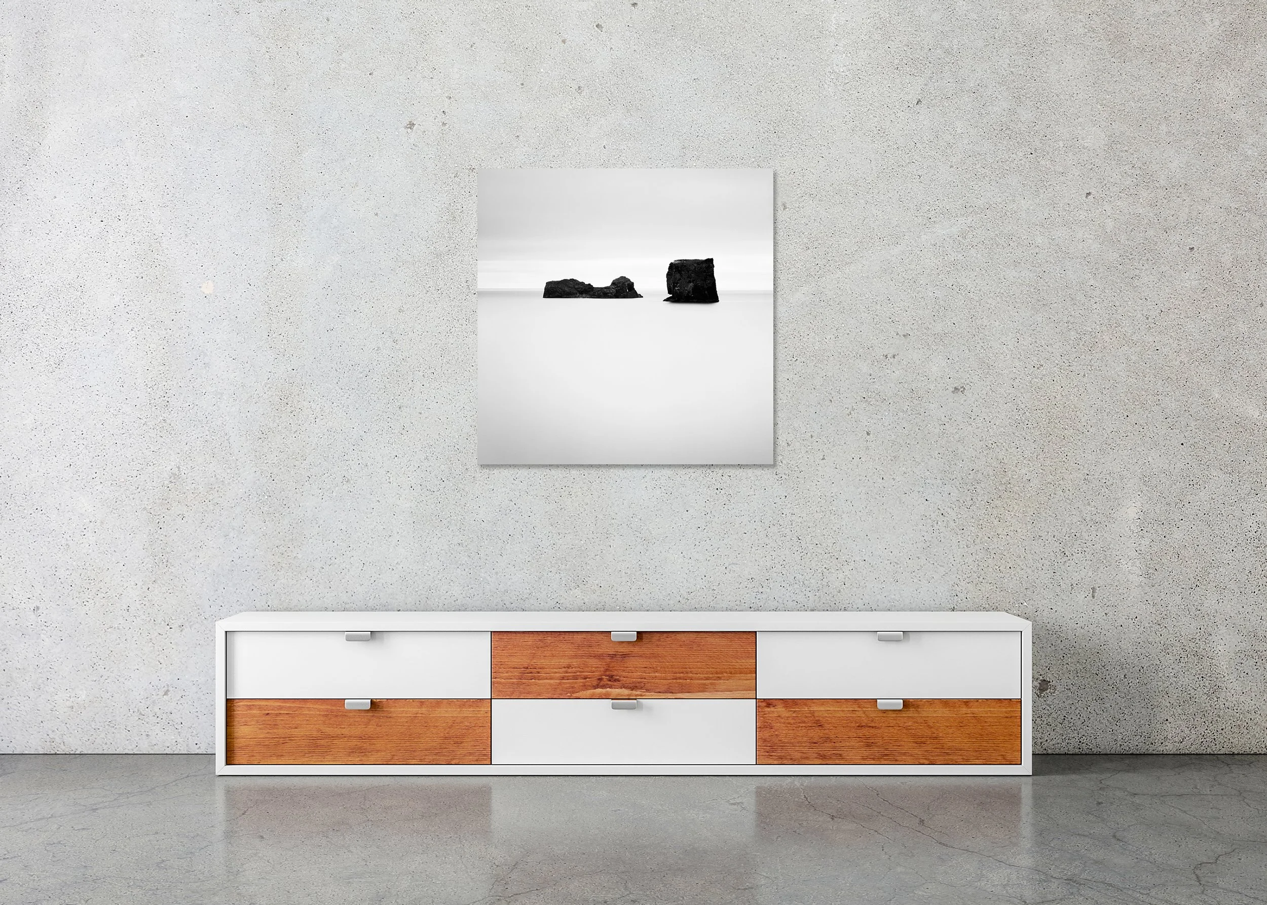 Black Rocks Study 1 – Iceland, frameless black-and-white photograph on aluminium Dibond displayed in a minimalist interior. Photo by Gerald Berghammer.