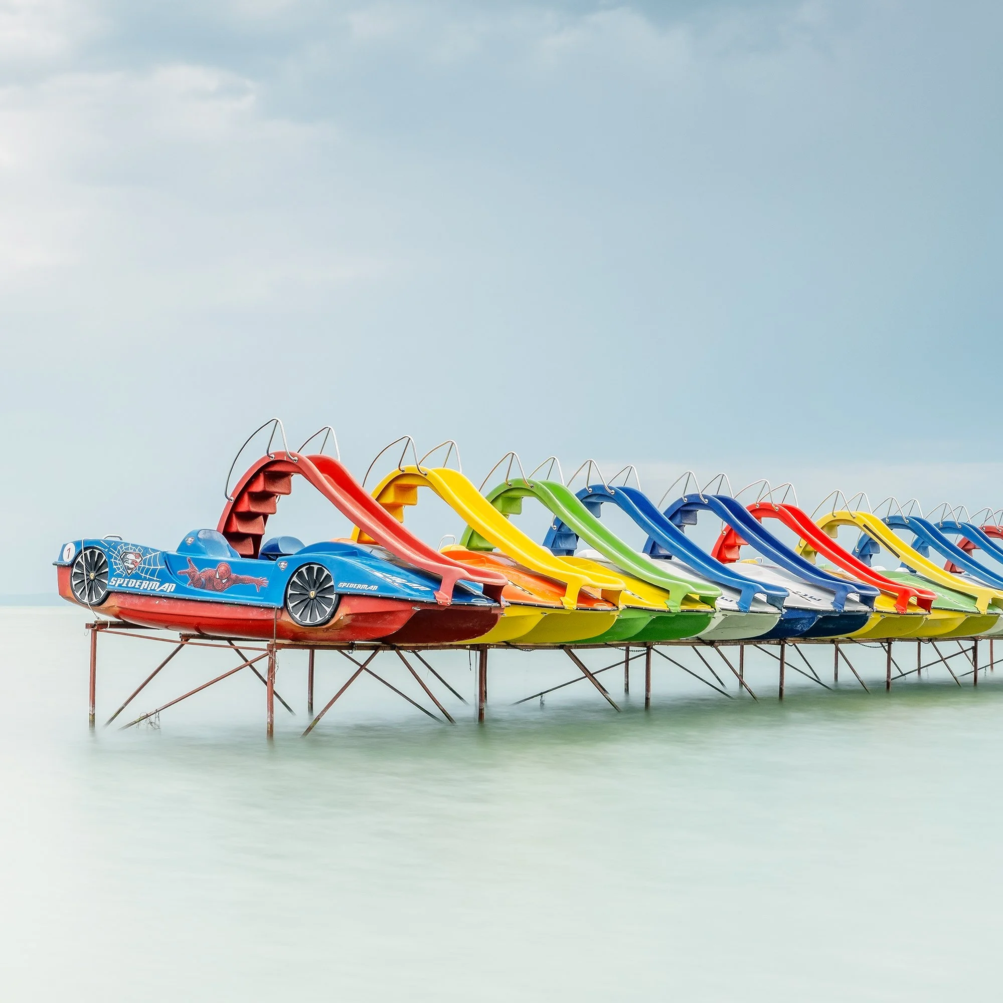© 2021 Gerald Berghammer - Color panorama waterscape photography. A row of colorful pedal boats on the lake Balaton with dramatic cloudy sky. Print detail 3