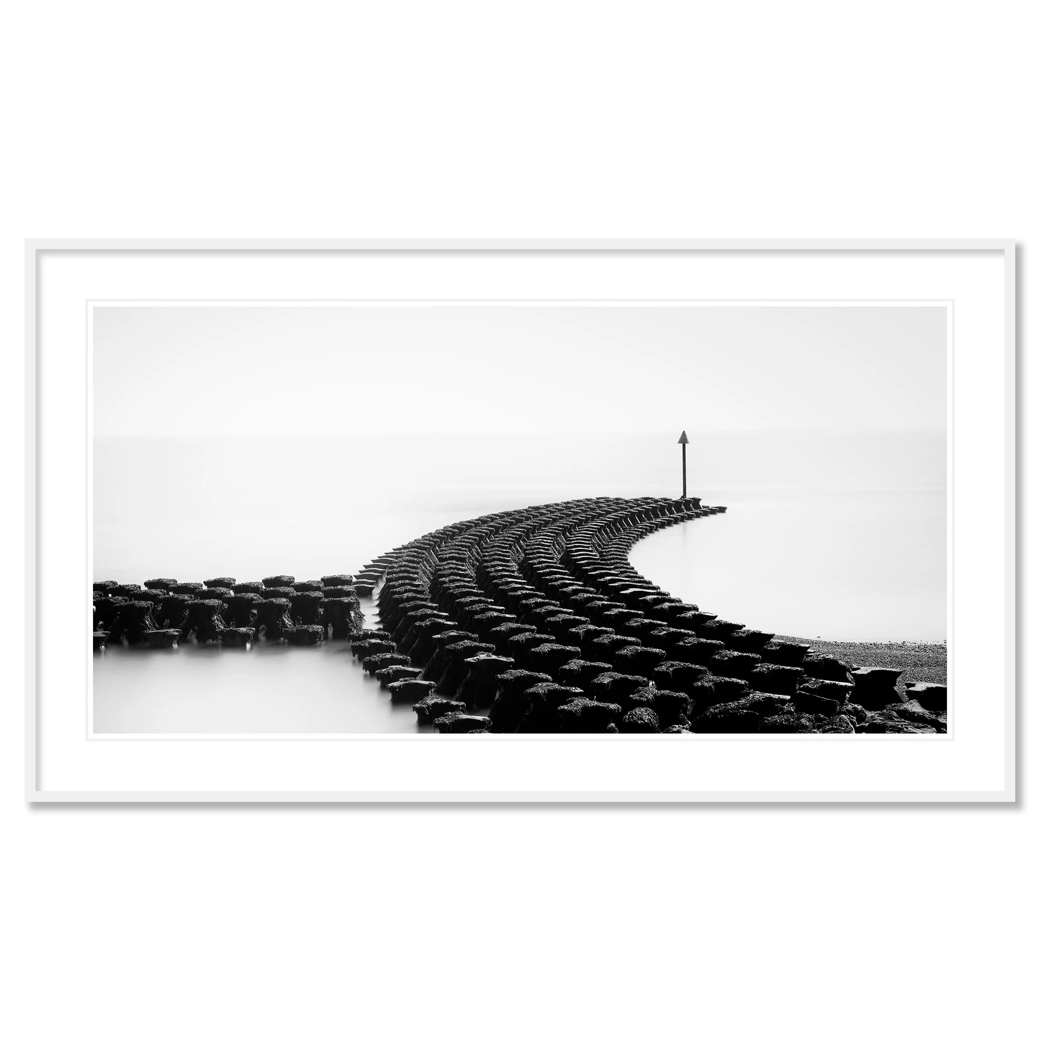 Gerald Berghammer - Black and white minimalist photography. A curved stone jetty extending into a calm body of water, with a tall navigation marker at the end. Classic framed white