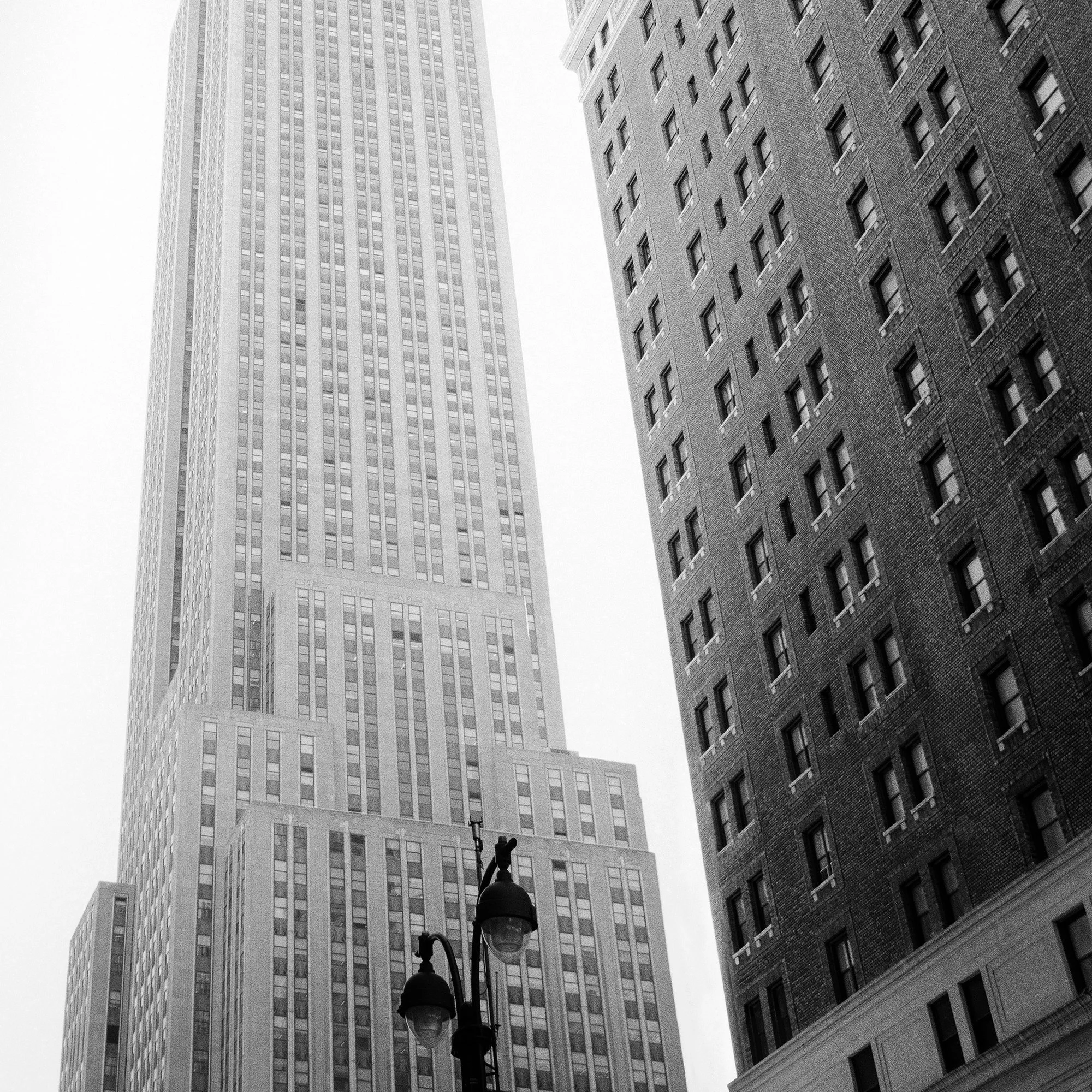 Detail of Empire State Building Study 1 by Gerald Berghammer showing the lower façade and neighbouring Manhattan architecture.