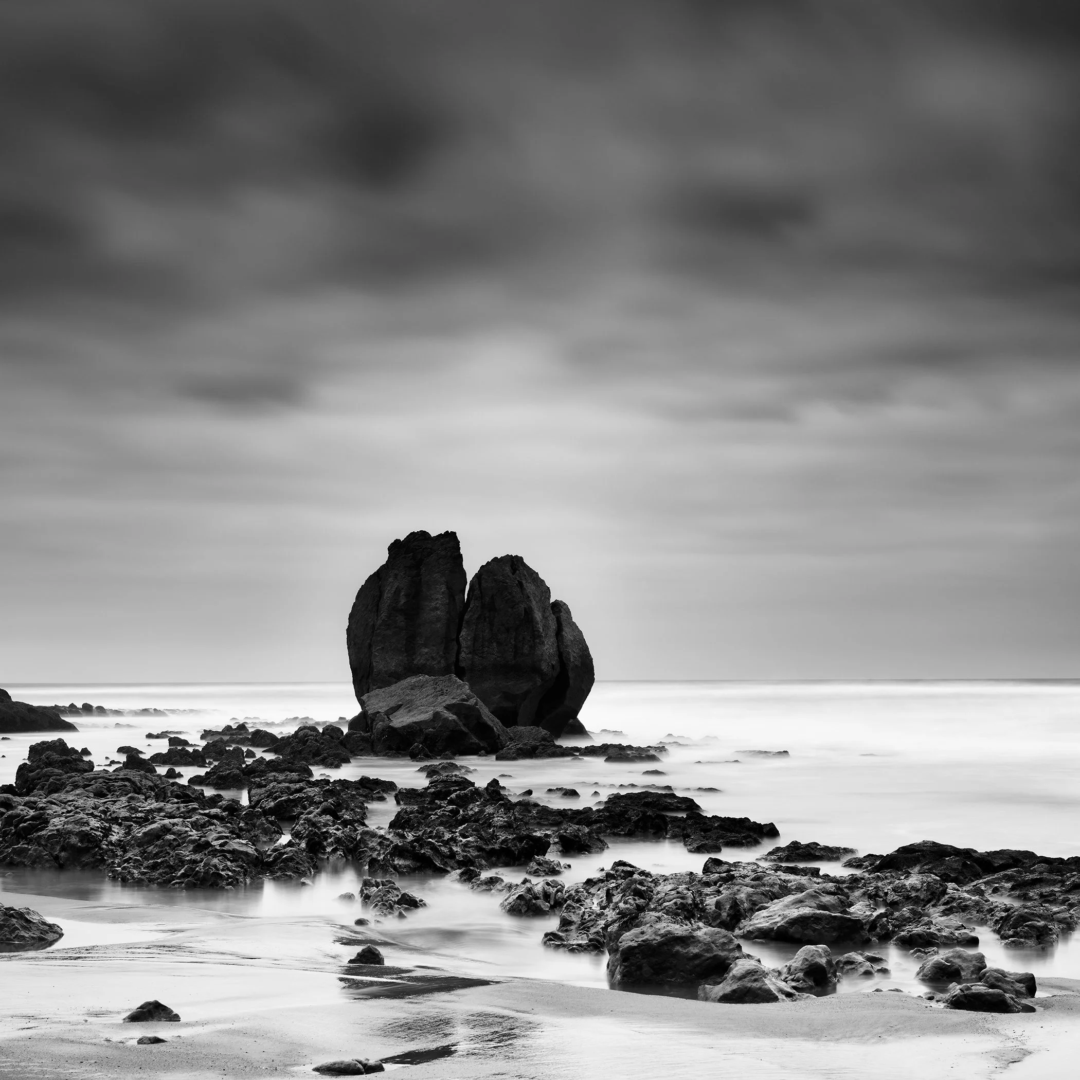Rocks on the Shore Study 2 by Gerald Berghammer, black-and-white long-exposure fine art photograph of a sculptural rock formation on the French coast.