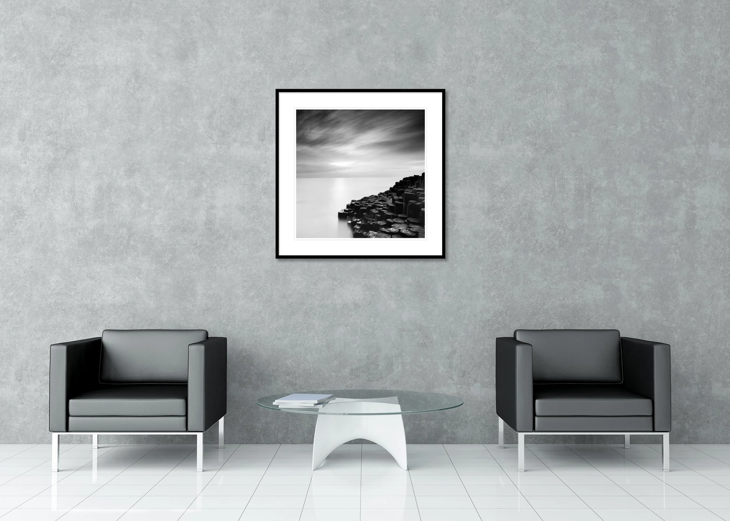 Giant’s Causeway Study 3 by Gerald Berghammer, black-and-white fine art print in a black aluminium frame with white mount displayed above two armchairs.