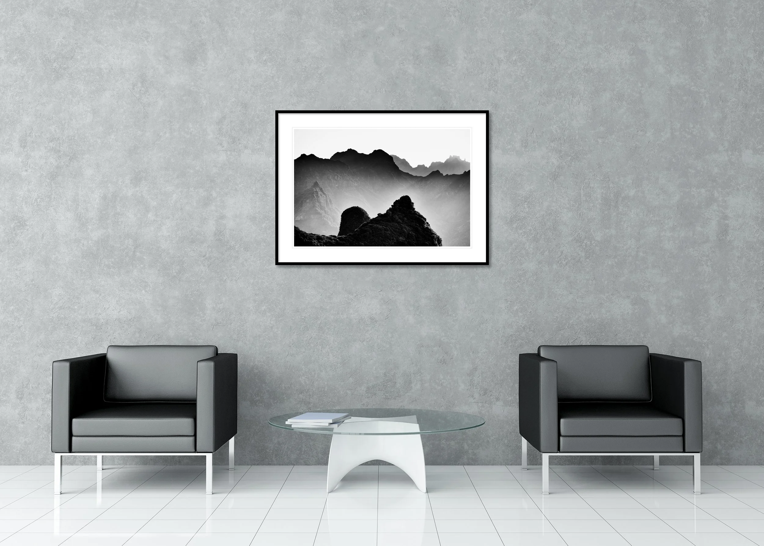 Black and white mountain photograph with steep peaks and textured hills fading into mist, archival pigment print in a classic frame with mount