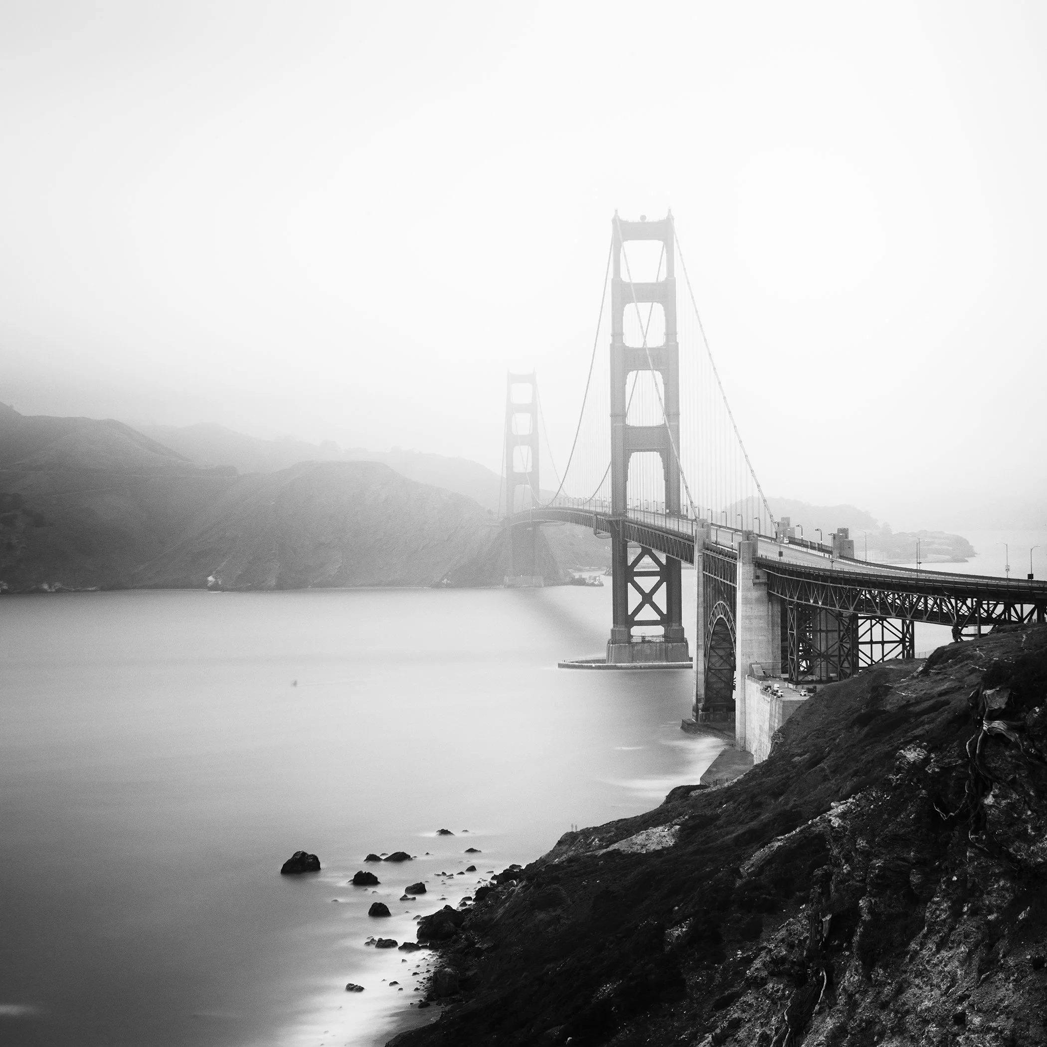 Black and white photograph of the Golden Gate Bridge in fog over San Francisco Bay