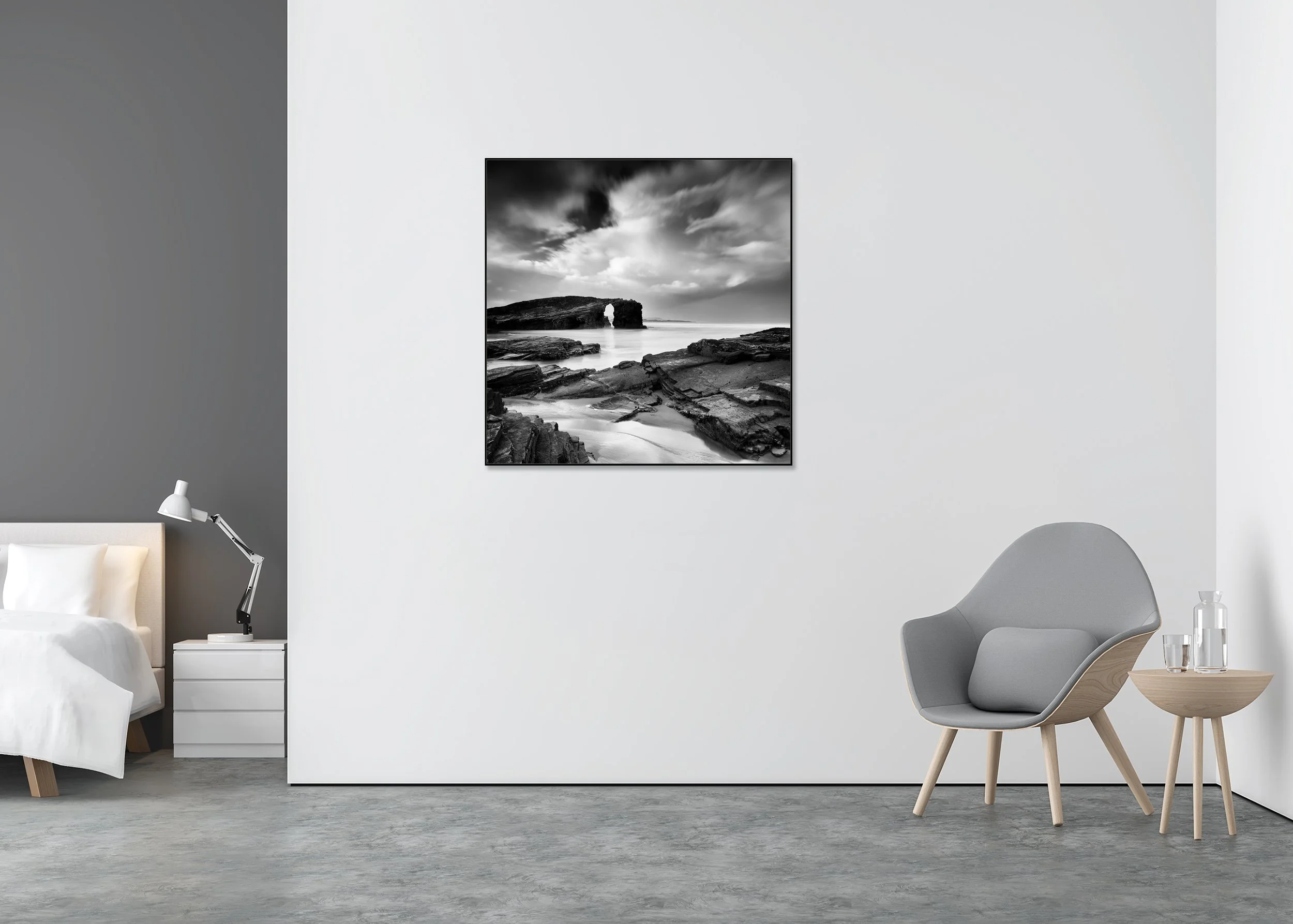 Black and white photo print of a rocky beach with a natural sea arch, calm water and dark clouds, mounted to Dibond in an aluminium ArtBox