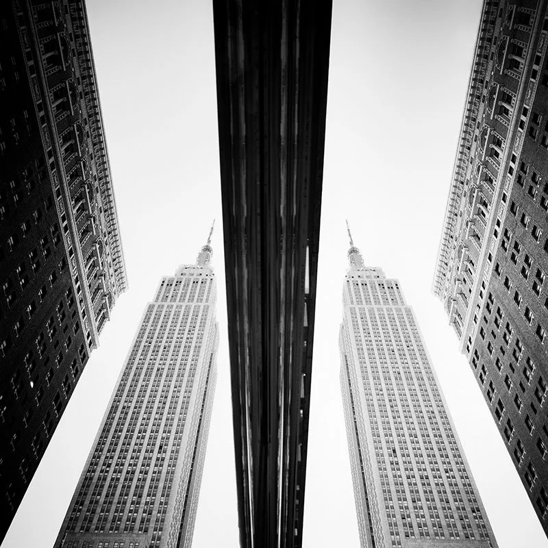 Empire State Building Study 2 by Gerald Berghammer, black-and-white analogue photograph of the Empire State Building reflected between New York skyscrapers.