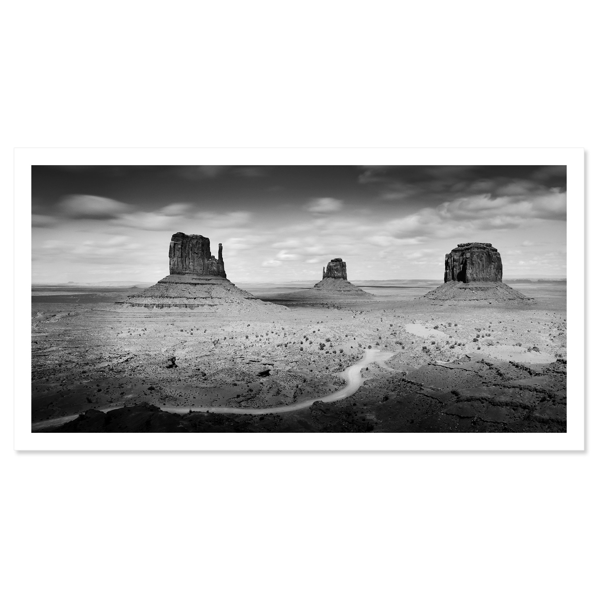 © 2015 Gerald Berghammer - Black and white photo. Large rock formations in a desert landscape, with a winding dirt road in the foreground and a cloudy sky above. Fine art print only