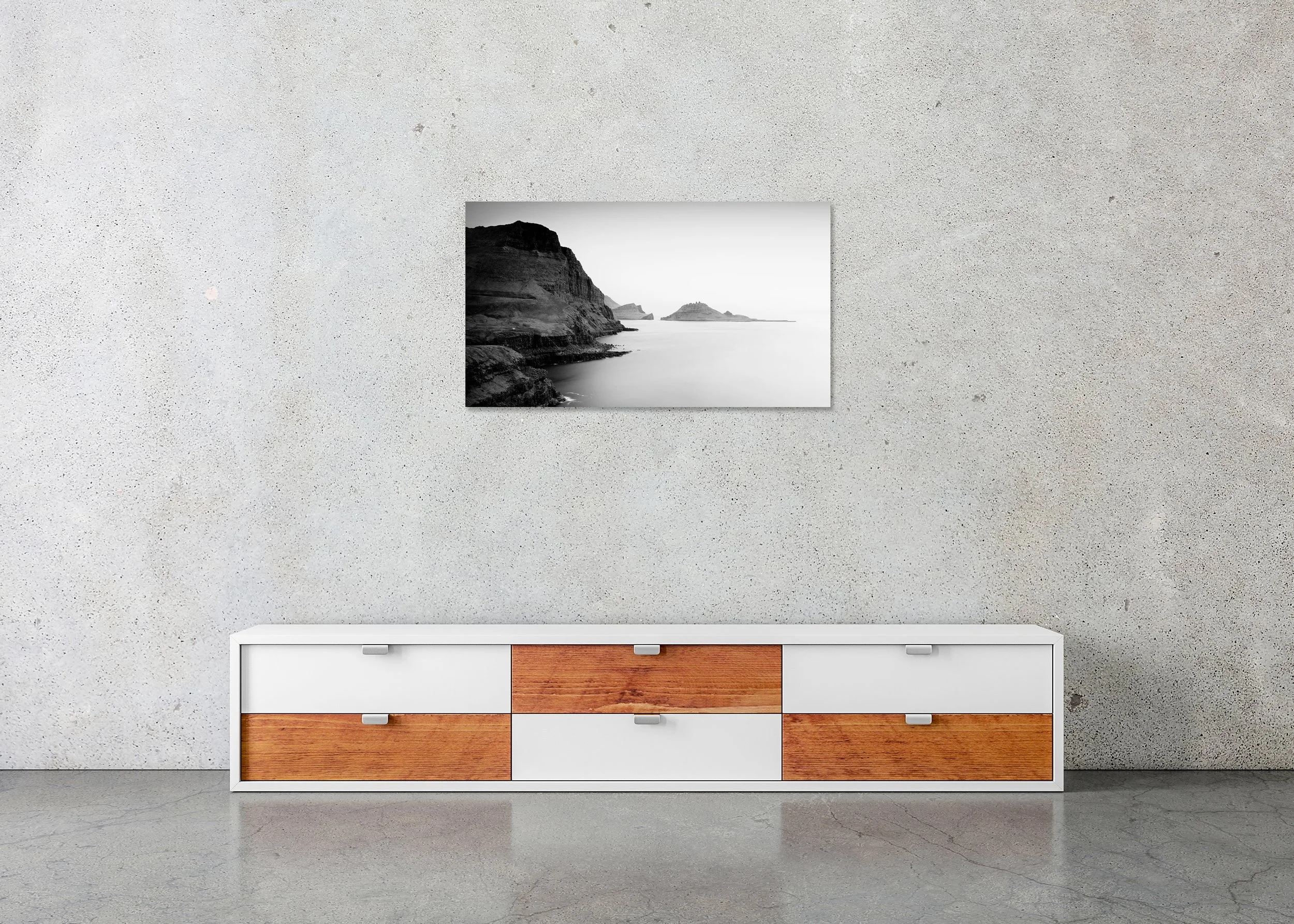 Rugged seaside cliffs and layered rock islands in a calm ocean, black and white photo print mounted on Dibond, frameless.