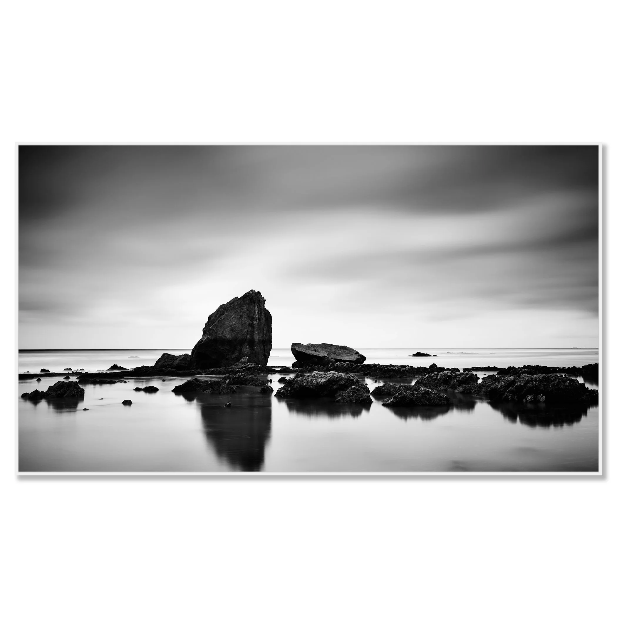 © 2023 Gerald Berghammer - Black and white minimalist beach seascape. A rocky shoreline with a large prominent rock formation in the water. Chromaluxe framed white