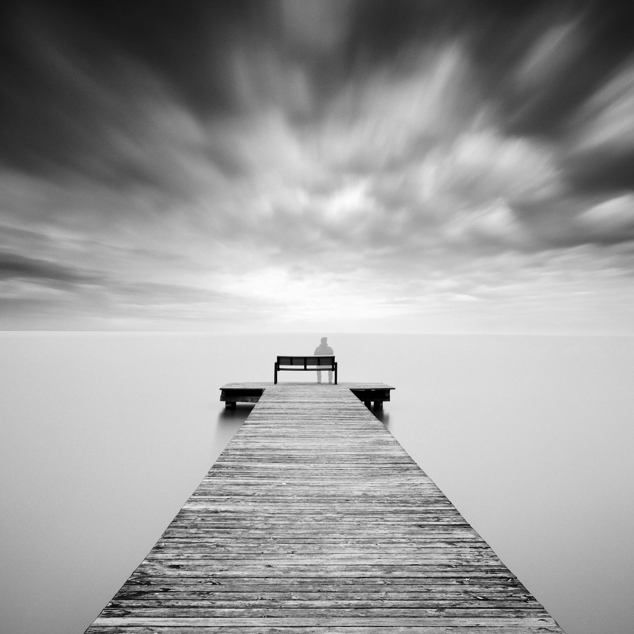 Self-Portrait Study 2, black-and-white fine art photograph of a solitary figure on a wooden pier at Lake Neusiedl, Austria, by Gerald Berghammer.