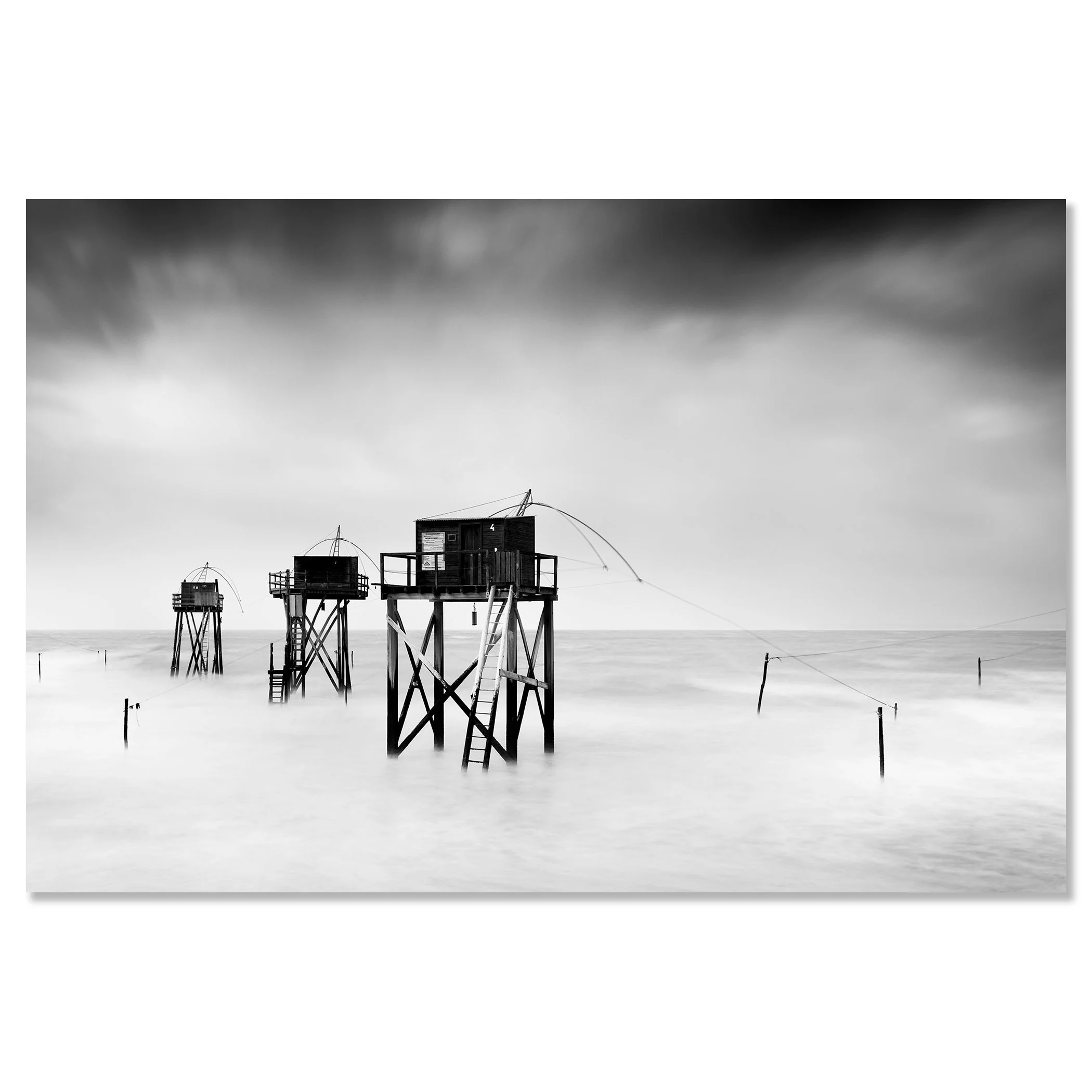 Monochrome long-exposure seascape with wooden fishing huts on stilts and misty water, ChromaLuxe frameless