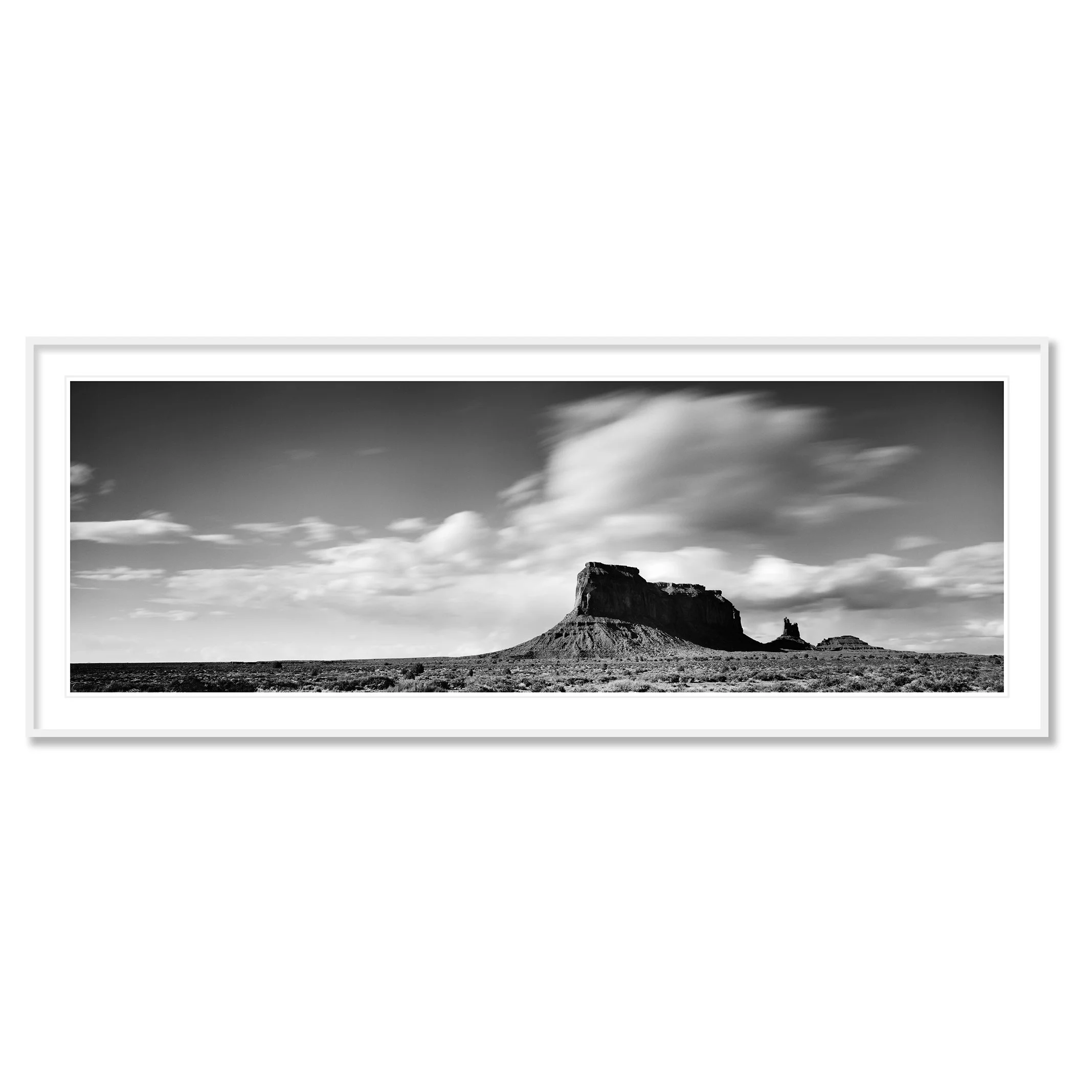 Gerald Berghammer - Black and white panorama desert photography. Flat-topped mesa with a smaller rock formation nearby, under a sky with scattered clouds. Classic framed white