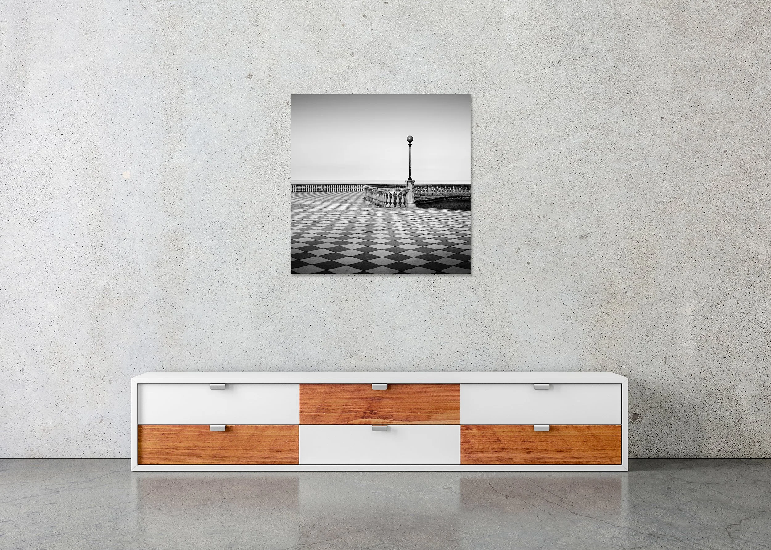 Black-and-white photo of an empty Tuscan seafront promenade with geometric tiles, balustrade and sea beyond, photo print mounted to Dibond, frameless.