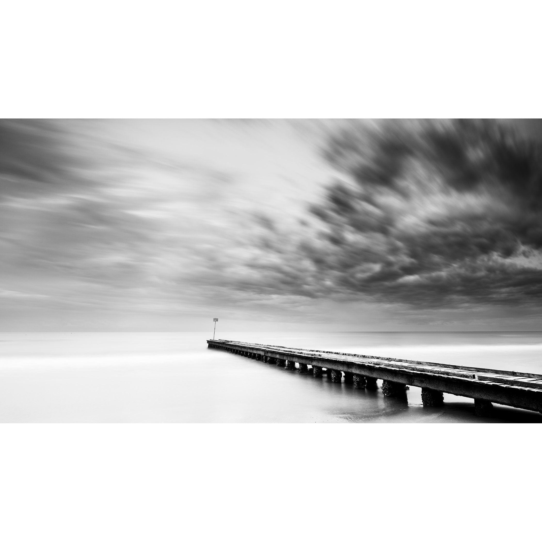 Stormy Adriatic Sea Panorama by Gerald Berghammer, minimalist black-and-white long-exposure seascape of a pier on the Adriatic coast of Italy.