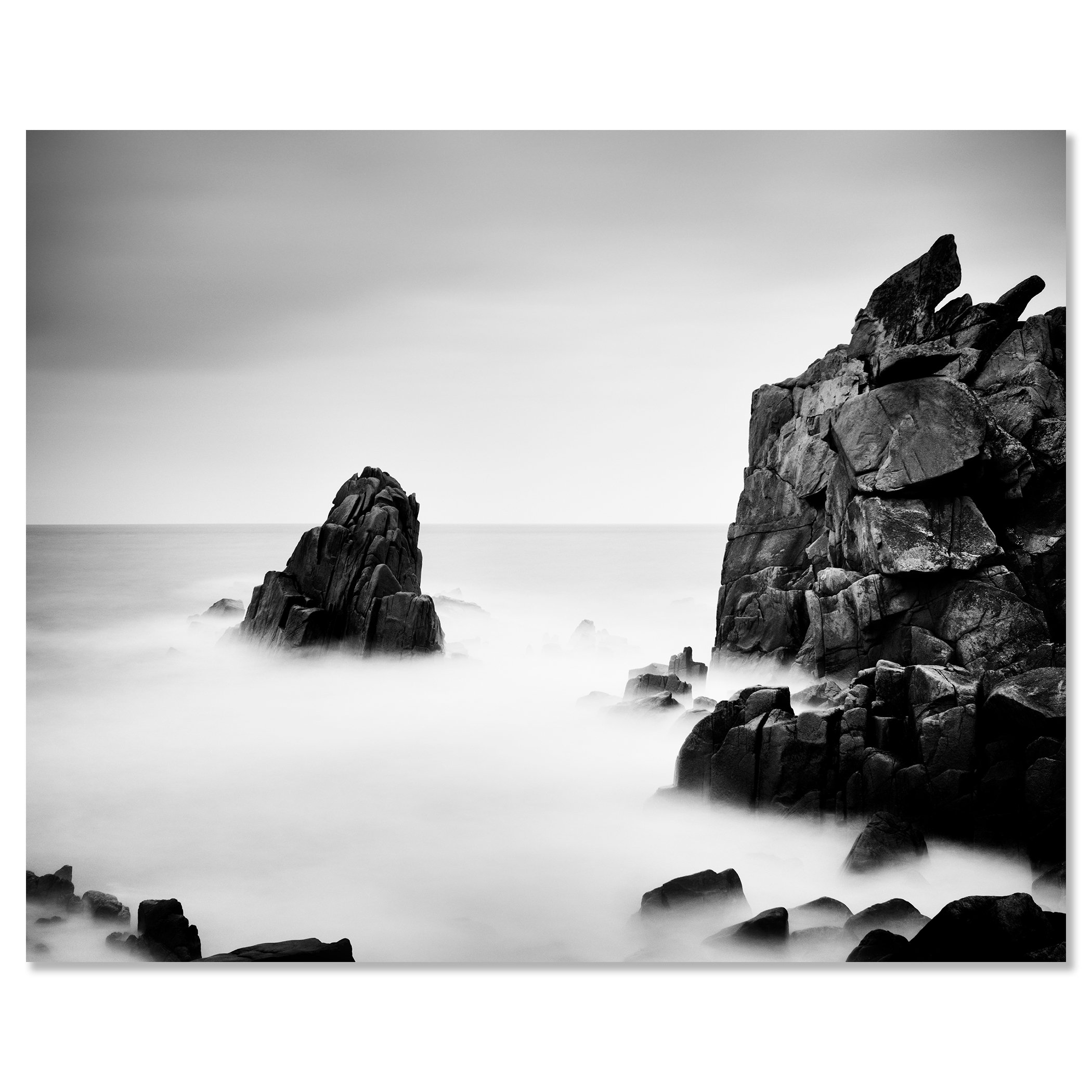 Black-and-white photograph of rocky sea cliffs and a lone sea stack in calm mist – dibond frameless
