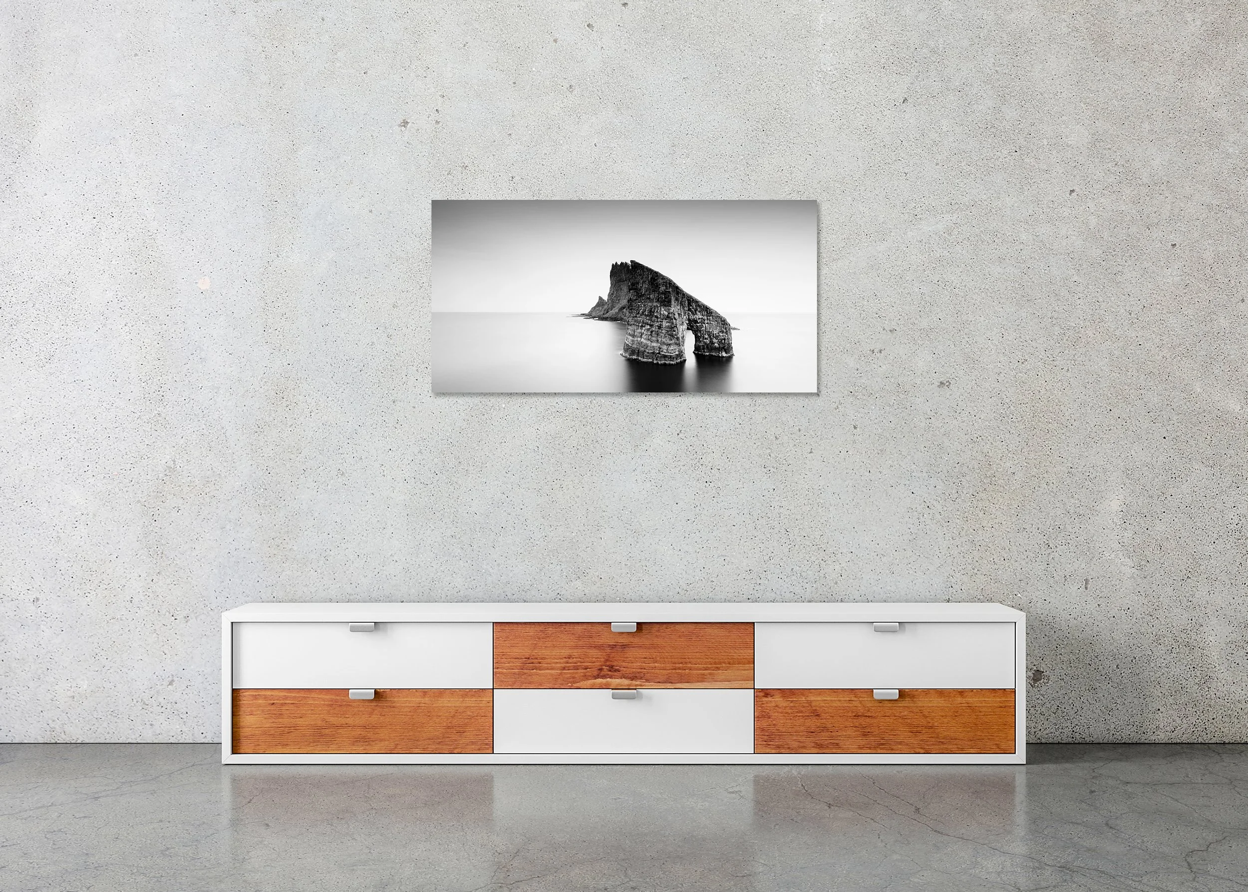 Drangarnir Sea Arch Panorama displayed in a modern interior as a frameless black-and-white artwork mounted on aluminium Dibond by Gerald Berghammer.