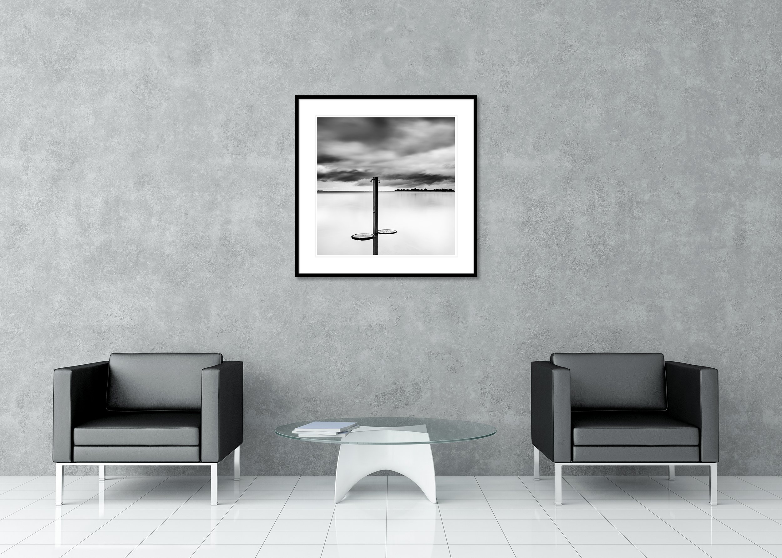 Beach shower in shallow water beneath a moody sky, fine art black-and-white archival pigment print in a classic frame with a mount.