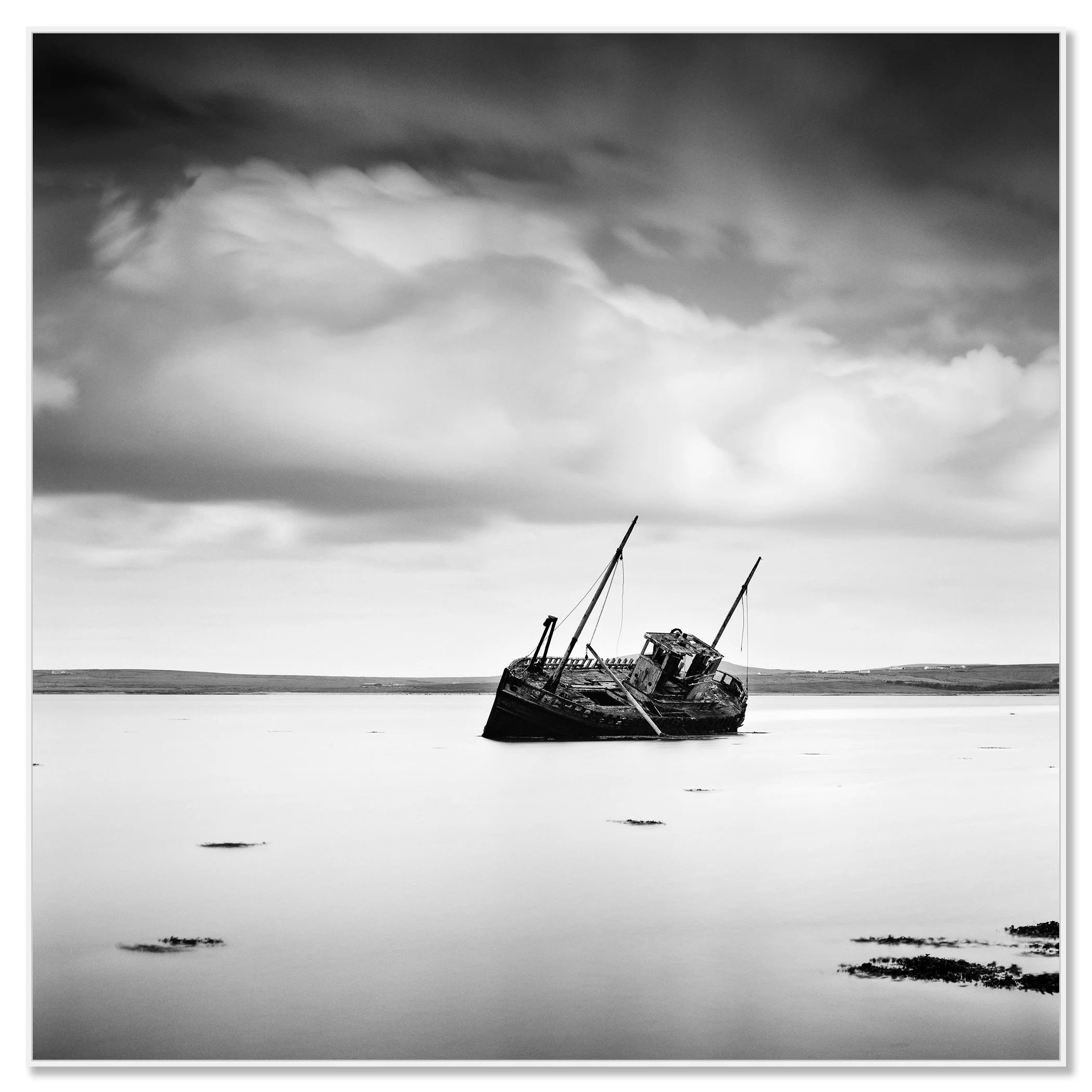 © 2014 Gerald Berghammer - Black and white minimalist seascape photography. An abandoned boat stuck in shallow water with cloudy sky overhead. Chromaluxe framed white