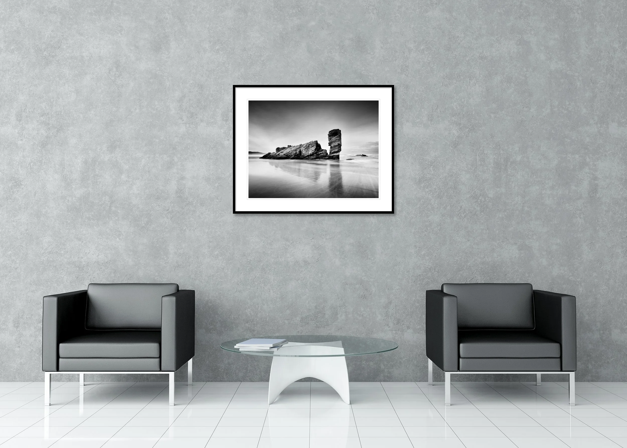 Monochrome long-exposure seascape print of a tall sea stack on a quiet beach, archival pigment print in a classic frame with mount